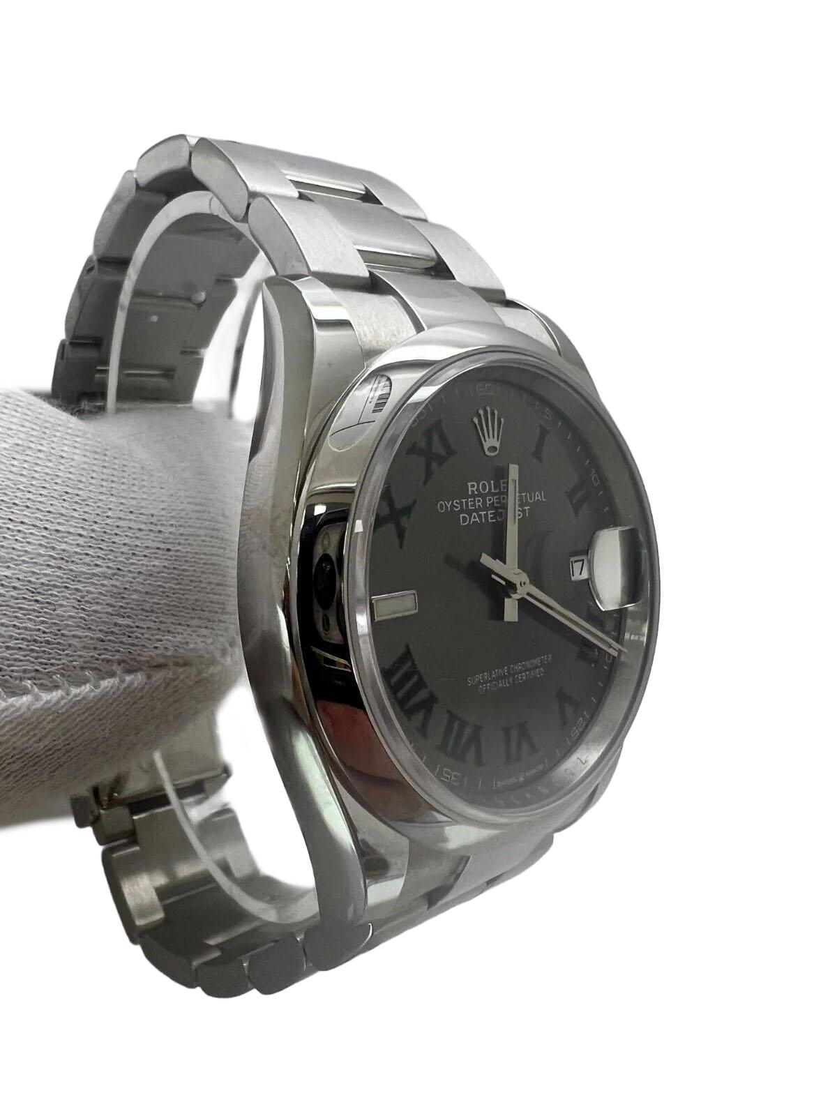 This elegant Rolex Datejust 126200 Wimbledon wristwatch is a perfect addition to any stylish collection. Featuring a sleek silver bezel and bracelet paired with a sophisticated gray sunburst dial, it combines Roman numeral and baton index markers