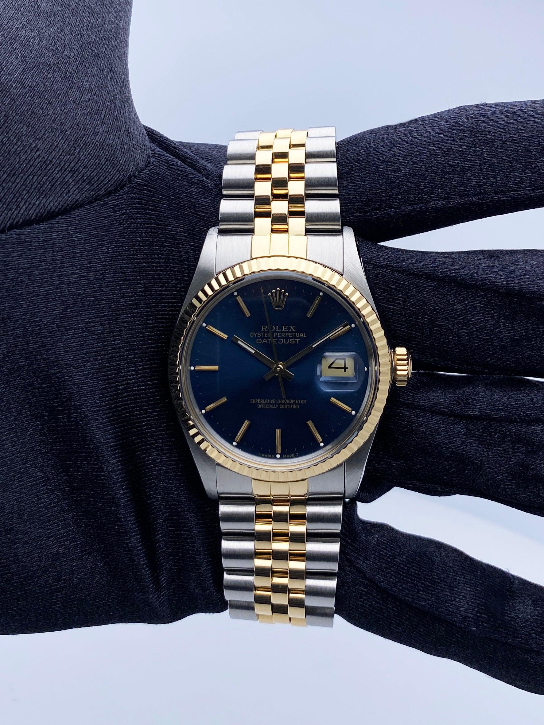 Rolex Datejust 16013 Mens Watch. 36mm stainless steel case. 18K yellow gold fluted bezel. Blue dial with gold hands and index hour markers. Minute markers on the outer dial. Date display at the 3 o'clock position. Stainless steel & 18K yellow gold