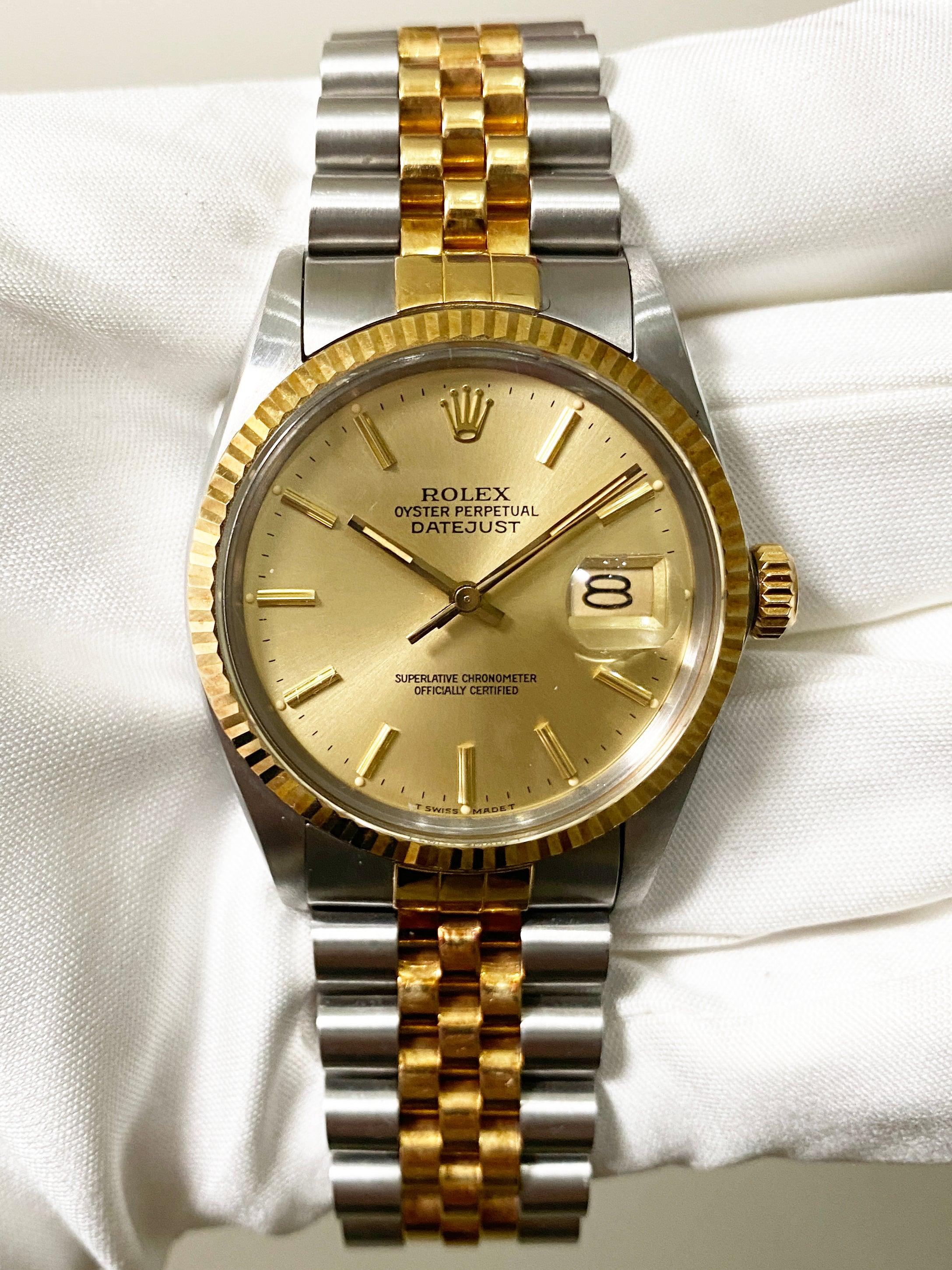 
Rolex Datejust 16013 Mens Watch. 36mm Stainless Steel case. 18k Yellow Gold fluted bezel. Champagne dial with gold hands and index hour markers. Minute markers on the outer dial. Date display at the 3 o'clock position. Stainless Steel & 18k yellow