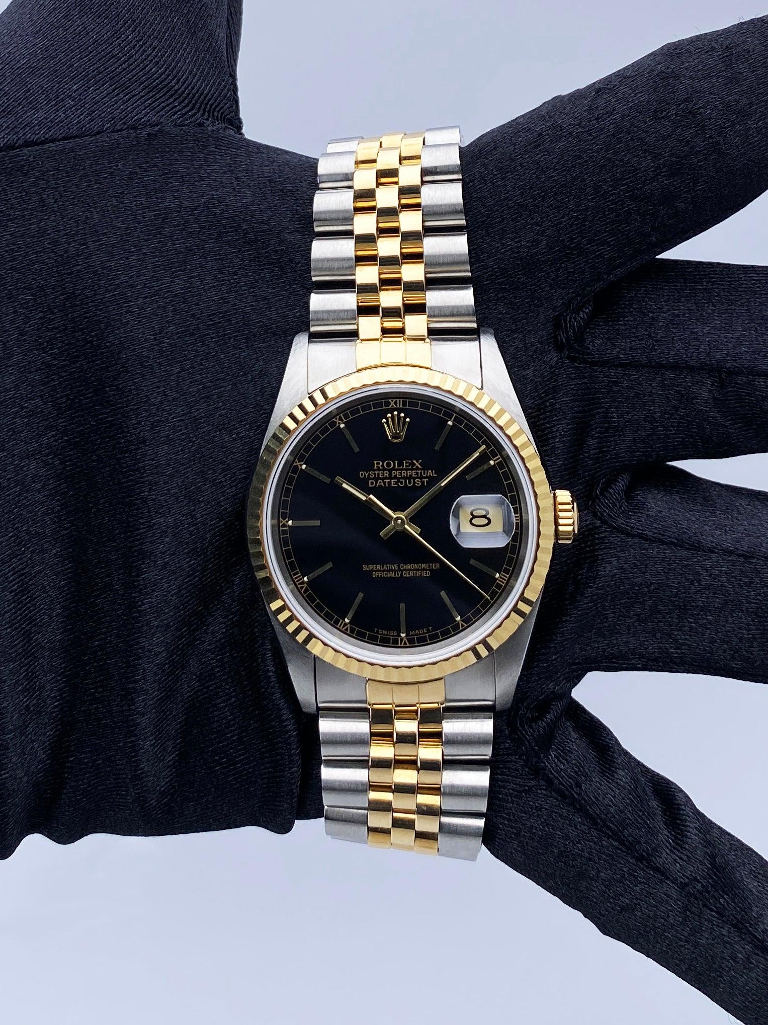 Rolex Datejust 16233 Mens Watch. 36mm stainless steel case. 18K yellow gold fluted bezel. Black dial with gold hands and gold index hour markers. Minute markers on the outer dial. Date display at the 3 o'clock position. Stainless steel & 18k yellow