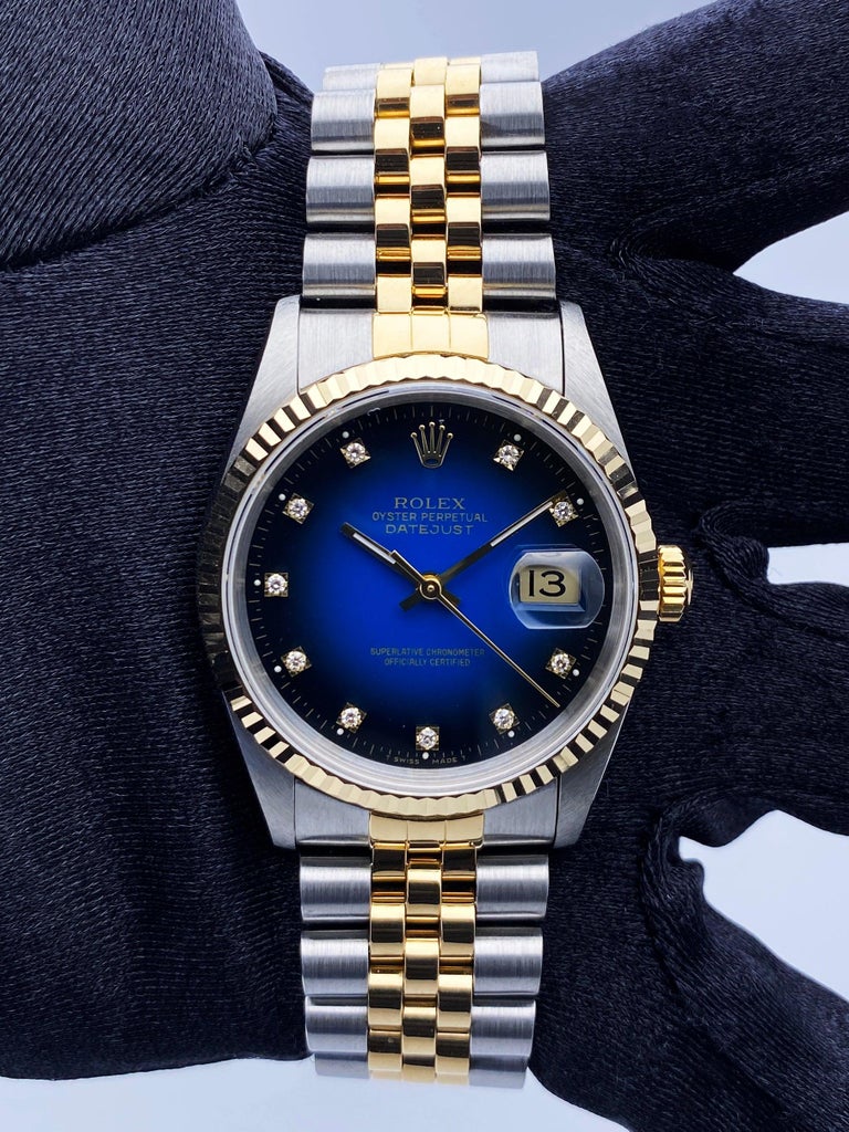 Rolex Datejust 16233 Mens Watch. 36mm stainless steel case. 18K yellow gold fluted bezel. Blue vignette dial with factory diamond hour markers. Minute markers on the outer dial. Date display at the 3 o'clock position. Stainless steel & 18K yellow