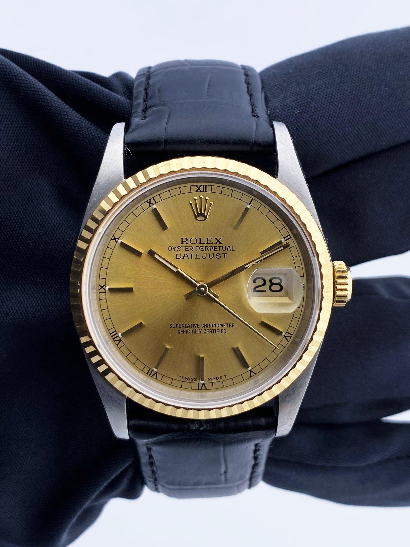 
Rolex Datejust 16233 Mens Watch. 36mm stainless steel case. 18K yellow gold fluted bezel. Champagne dial with gold hands and Index hour markers. Minute markers on the outer dial. Date display at the 3 o'clock position. Black leather strap