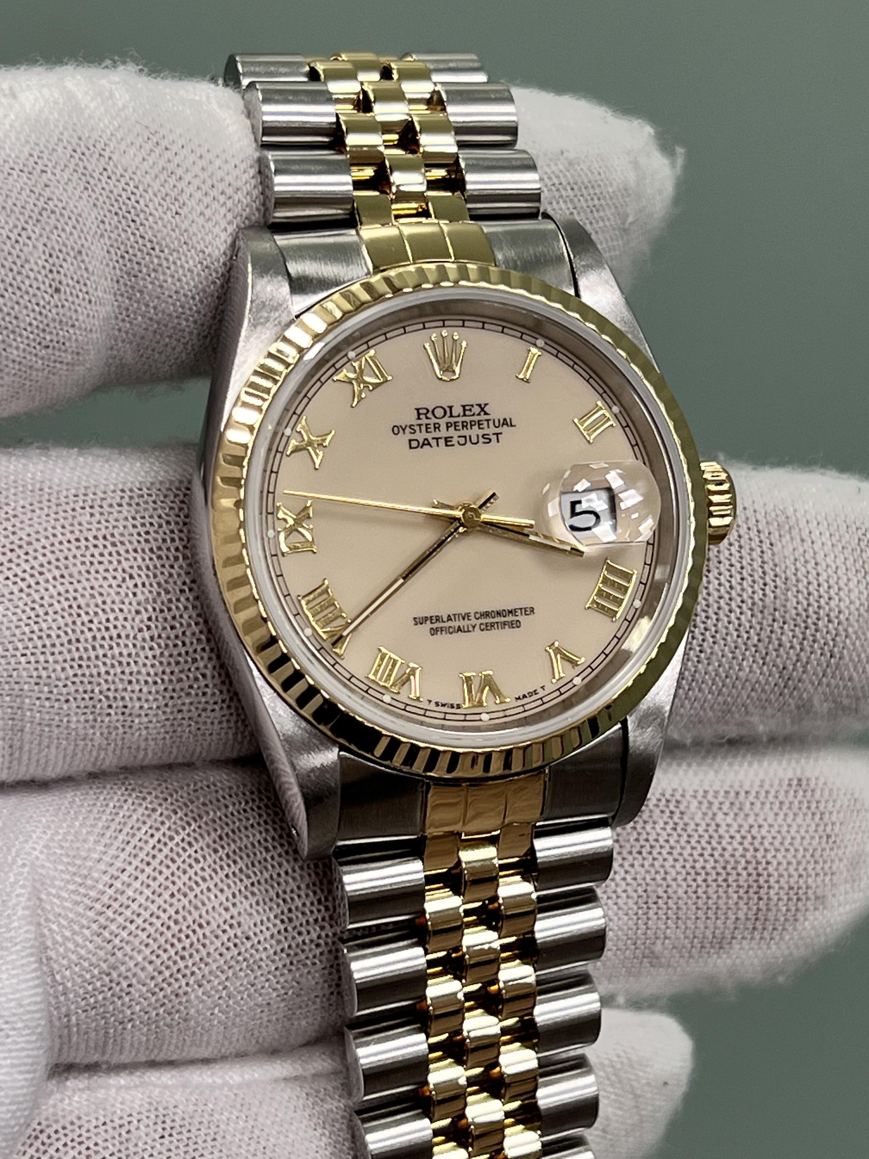 Style Number: 16233
Serial: X795****
Year: 1991
Model: Rolex Datejust
Case Material: Stainless Steel 
Band: 18k Yellow Gold & Stainless Steel 
Bezel: 18k Yellow Gold Fluted Bezel
Dial: Cream Roman Dial 
Face: Sapphire Crystal 
Case Size: 36mm