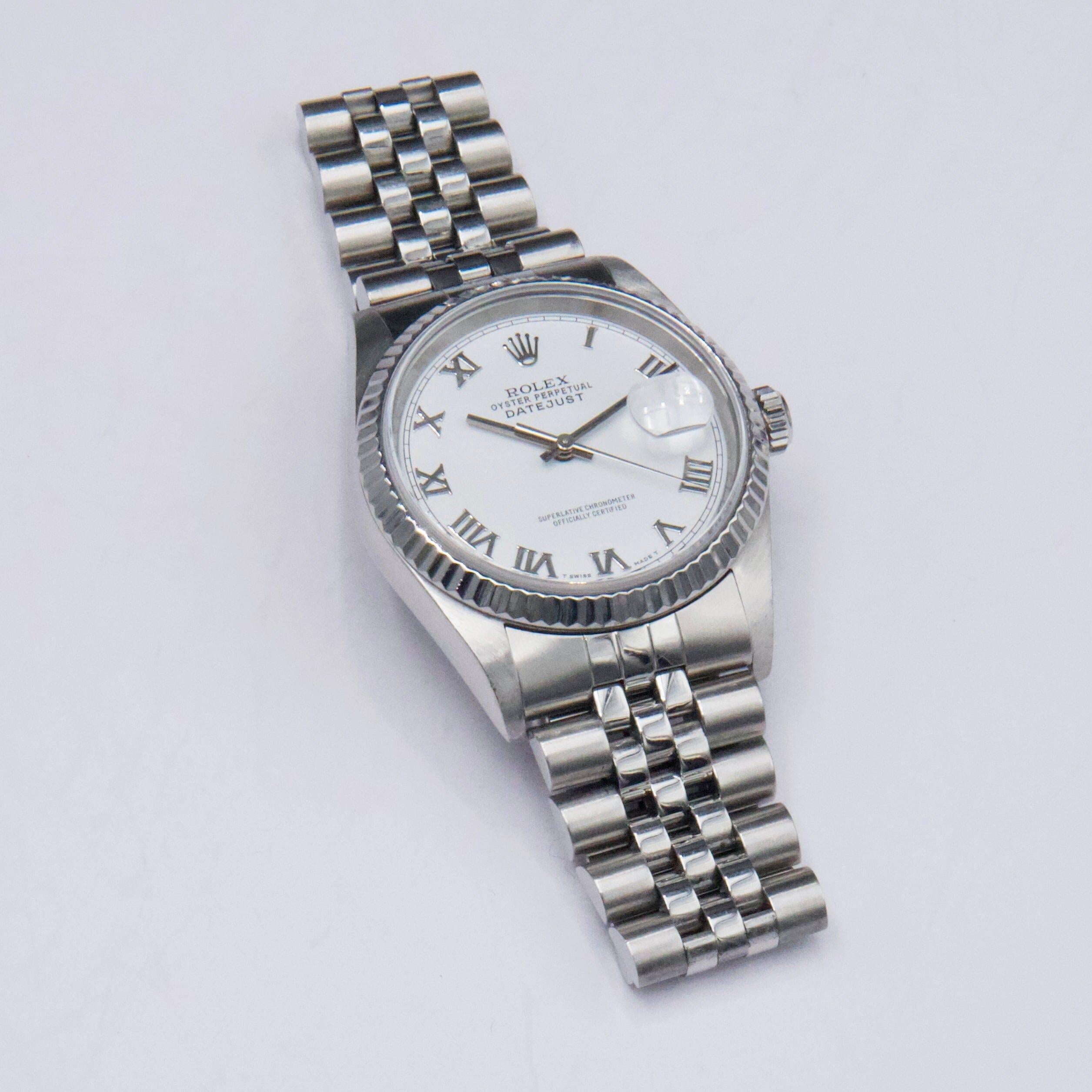 Rolex Oyster Perpetual Datejust 16234 Mens Watch. 36mm stainless steel case with 18K white gold fluted bezel. White dial with steel hands and Roman numeral hour markers. Minute marker around the outer dial. Date display at 3 o'clock position.
