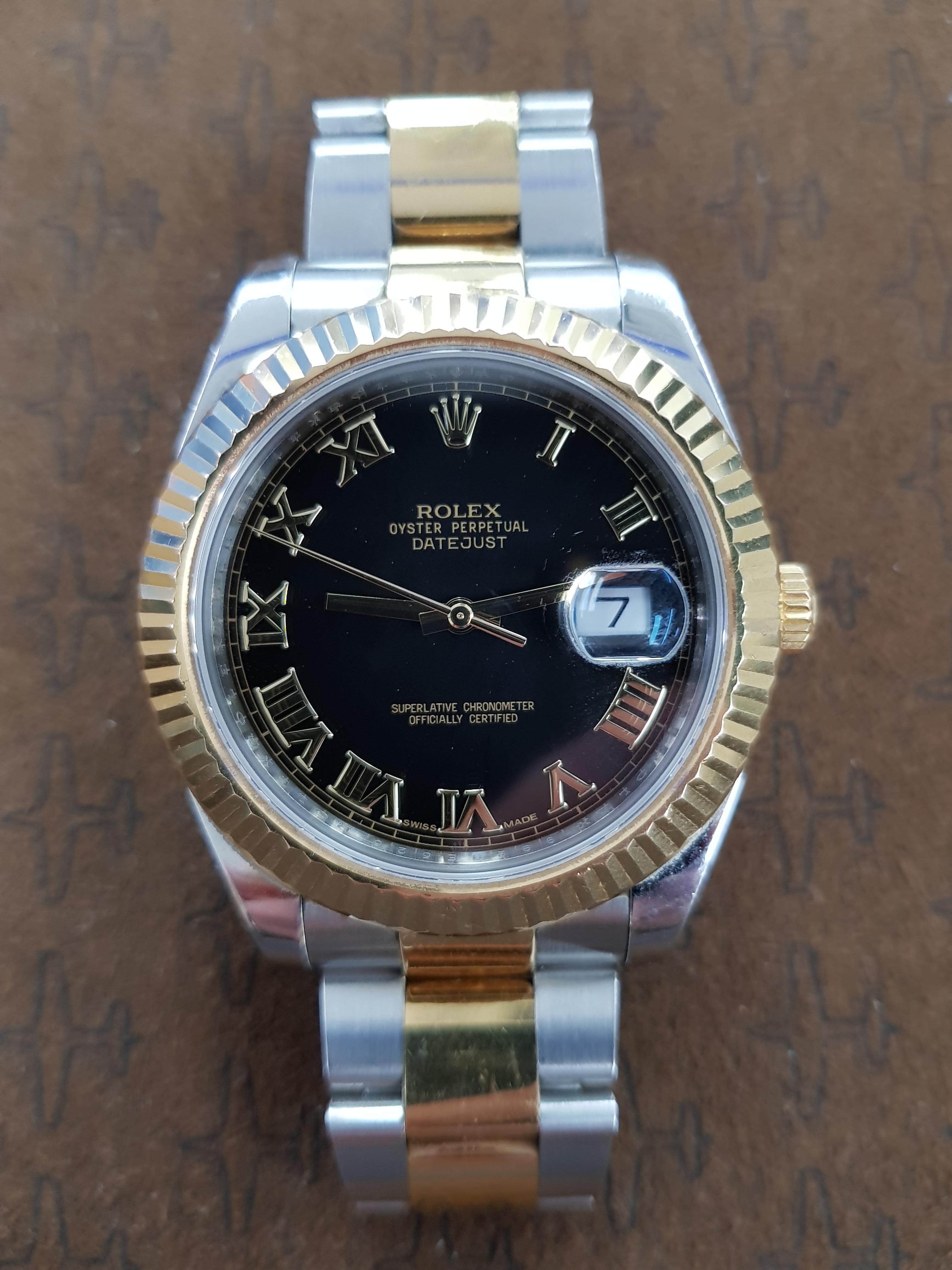 Rolex Date Just 2 in bi-metal stainless steel and yellow gold with a black dial and 41 mm fluted bezel. This watch comes with full Rolex certification.