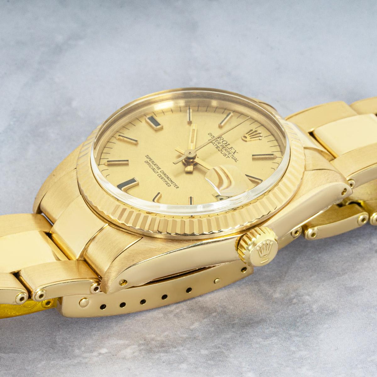 A midsize Rolex Datejust crafted in yellow gold. Featuring a champagne dial with applied hour markers and a distinctive black colouring at 6 and 9 o'clock as well as a fluted yellow gold bezel. The watch is also fitted with a plastic glass,