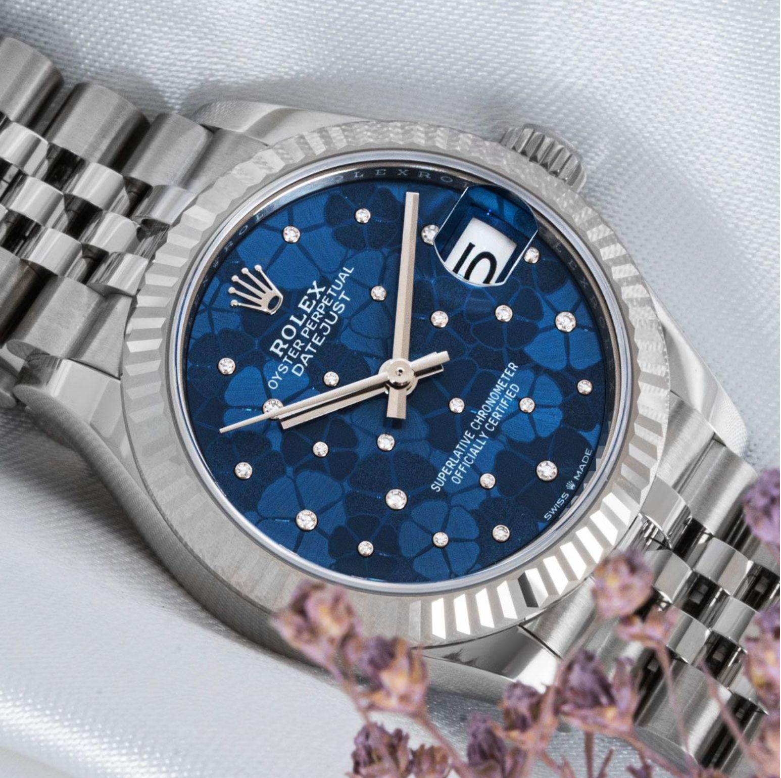 A stainless steel 31mm Datejust by Rolex. Featuring a blue floral motif diamond-set dial and a white gold fluted bezel. The steel Jubilee bracelet is equipped with a concealed folding Crownclasp. Fitted with a scratch-resistant sapphire crystal and