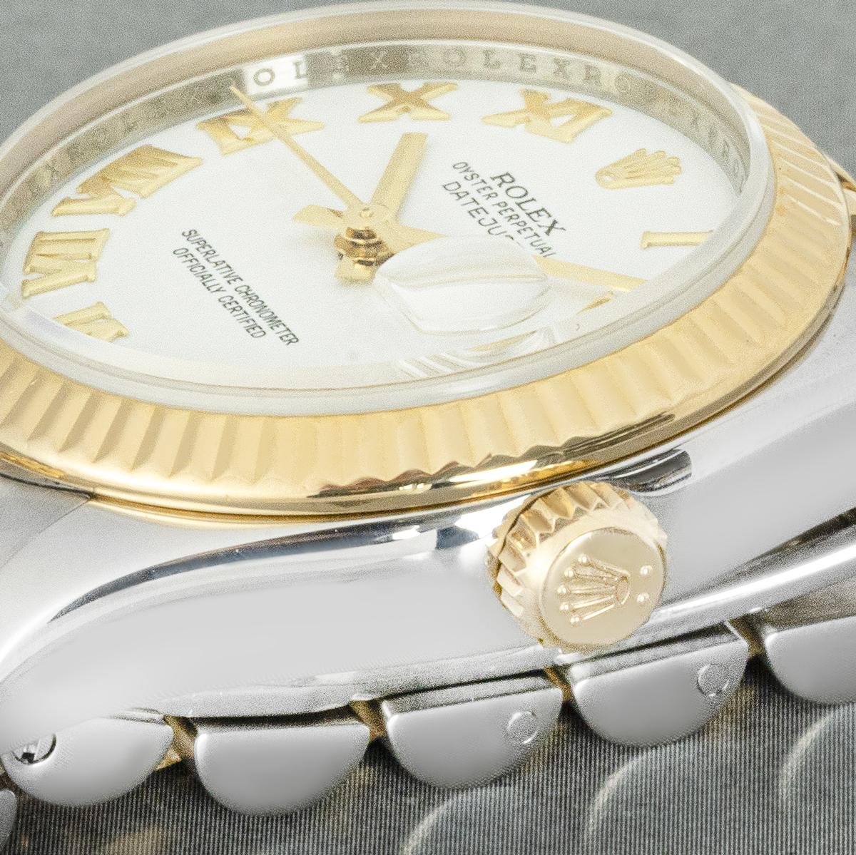 A 31mm stainless steel and 18k yellow gold Datejust ref. 178273 by Rolex. Featuring a white dial with Roman numerals and a yellow gold fluted bezel. Fitted with sapphire crystal and a self-winding automatic movement. The watch is presented on a