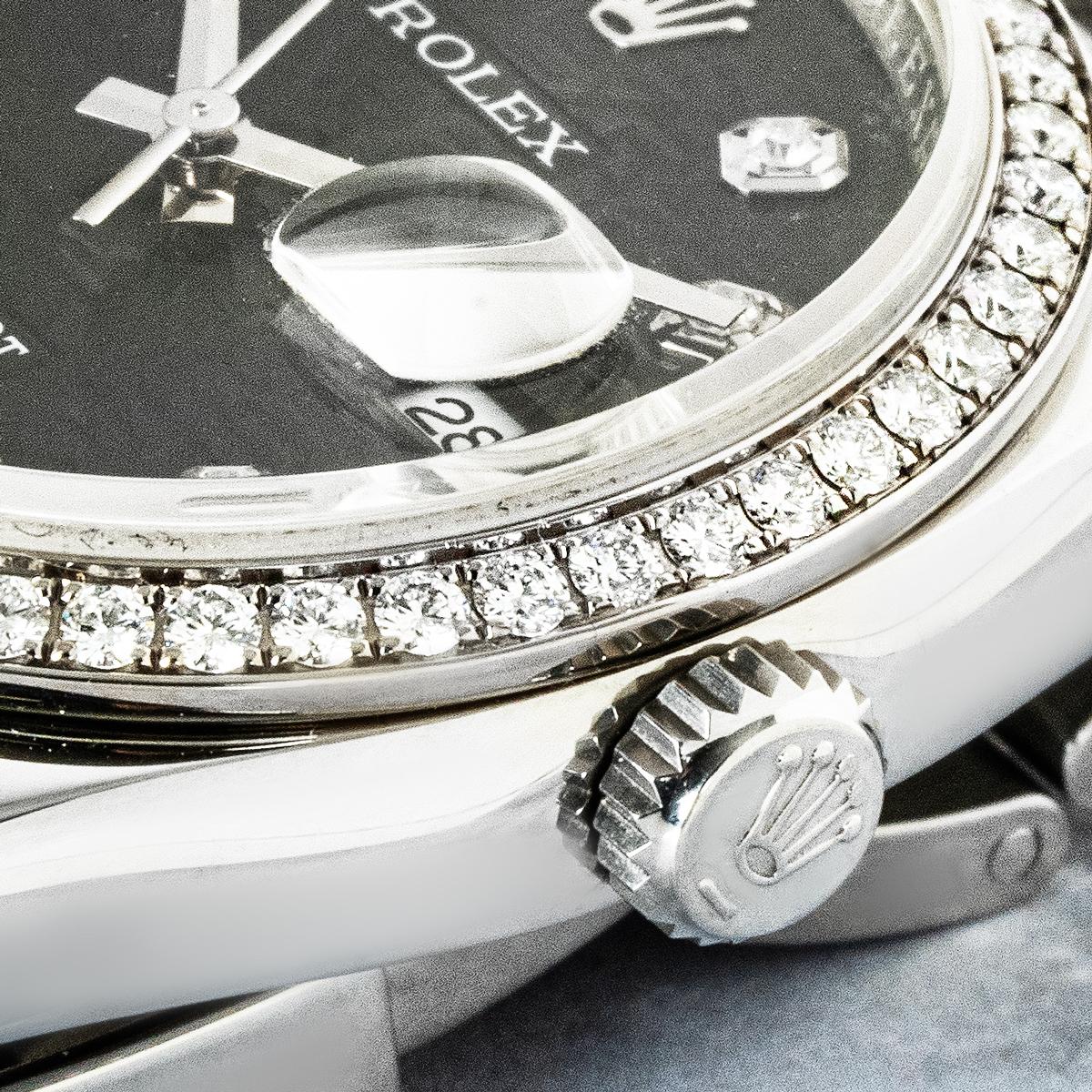 Un Rolex Datejust de 36 mm, tamaño medio, de acero inoxidable, referencia 116244, con esfera Jubilee negra de diamantes y bisel engastado de fábrica adornado con 52 diamantes redondos talla brillante. Está equipado con un brazalete Oyster sujeto por