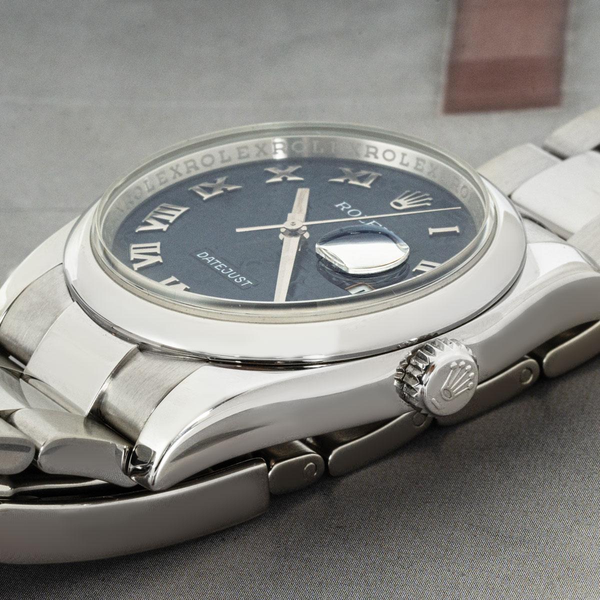 Eine 36-mm-Datejust von Rolex aus Edelstahl. Blaues Jubiläumszifferblatt mit aufgesetzten römischen Ziffern und glatter Lünette.

Ausgestattet mit Saphirglas und automatischem Uhrwerk mit Automatikaufzug. Die Uhr ist außerdem mit einem