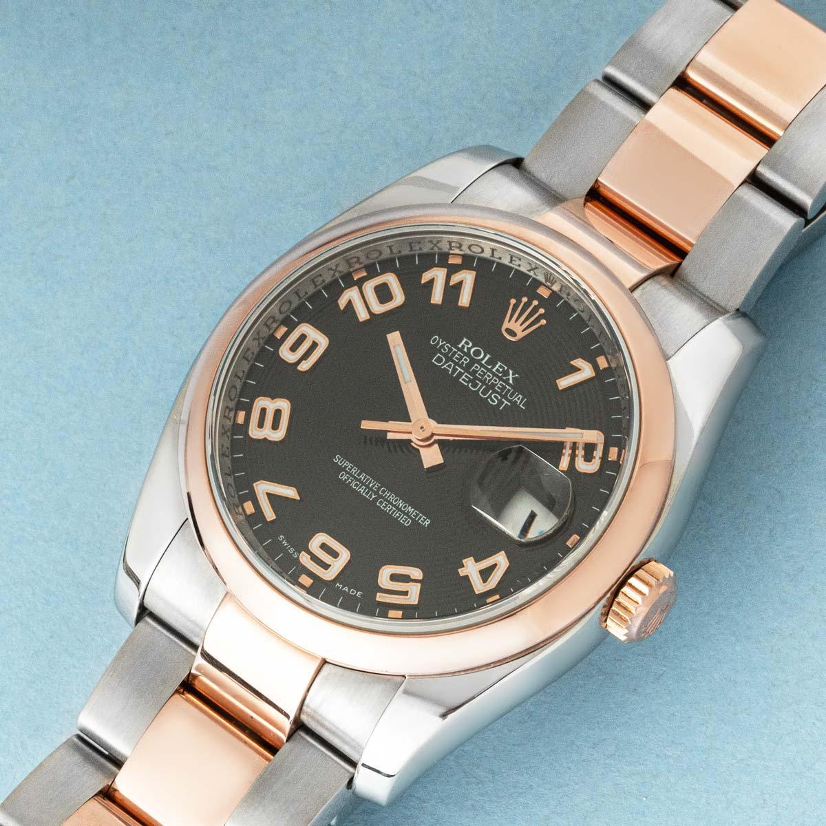 Un Rolex Datejust de 36 mm referencia 116201 de acero inoxidable y oro rosa, con una distintiva esfera concéntrica negra con números arábigos y manecillas luminosos.

Uno de sus detalles más deseables es la rara rueda de fecha 