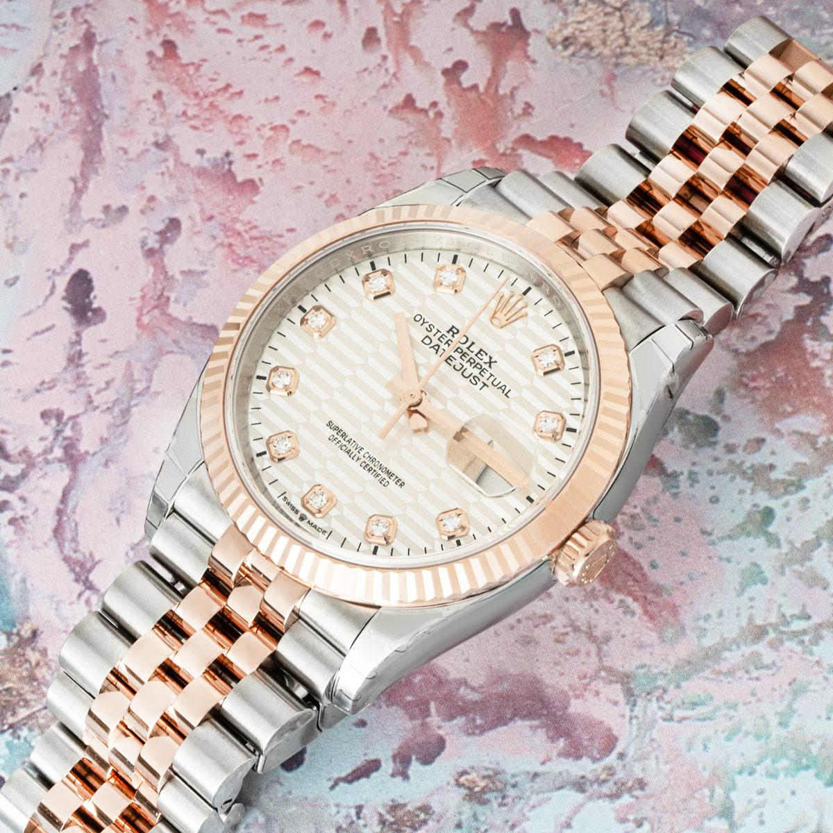 A Datejust 36 in stainless steel and rose gold by Rolex. Features the discontinued silver fluted motif dial with diamond set hour markers and a fluted rose gold bezel. This watch is presented on a Jubilee bracelet which is equipped with the folding