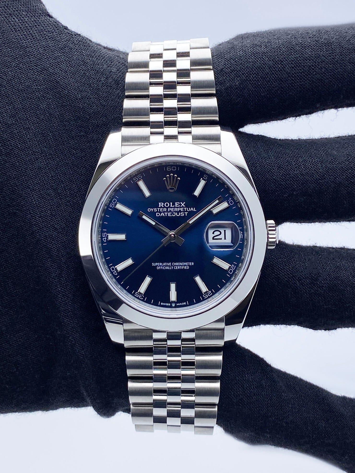 Rolex Datejust 41 126300 Orologio da uomo. Cassa in acciaio inossidabile da 41 mm con lunetta liscia in acciaio inossidabile. Quadrante blu con lancette in acciaio luminose e indici luminosi. Datario a ore 3. Bracciale Jubilee in acciaio
