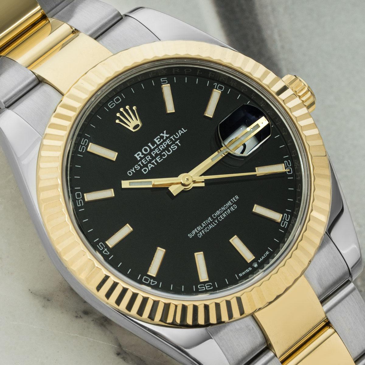 A steel and gold 41mm mens Datejust by Rolex. Featuring a black dial with applied hour markers and a smooth yellow gold bezel. Fitted with a sapphire crystal, a self-winding automatic movement, a steel and gold Oyster bracelet equipped with a