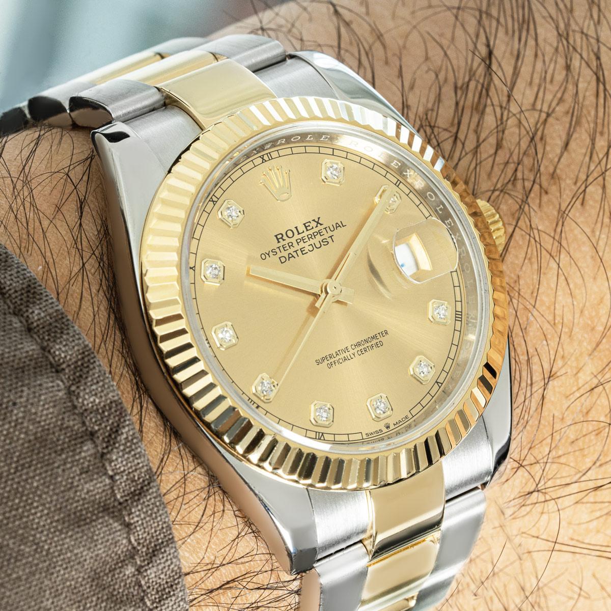 A 41mm Datejust in Oystersteel and yellow gold by Rolex. Features a champagne diamond-set dial, complemented by a yellow gold fluted bezel. Fitted with a sapphire crystal and a self-winding automatic movement. The watch is presented on an Oyster