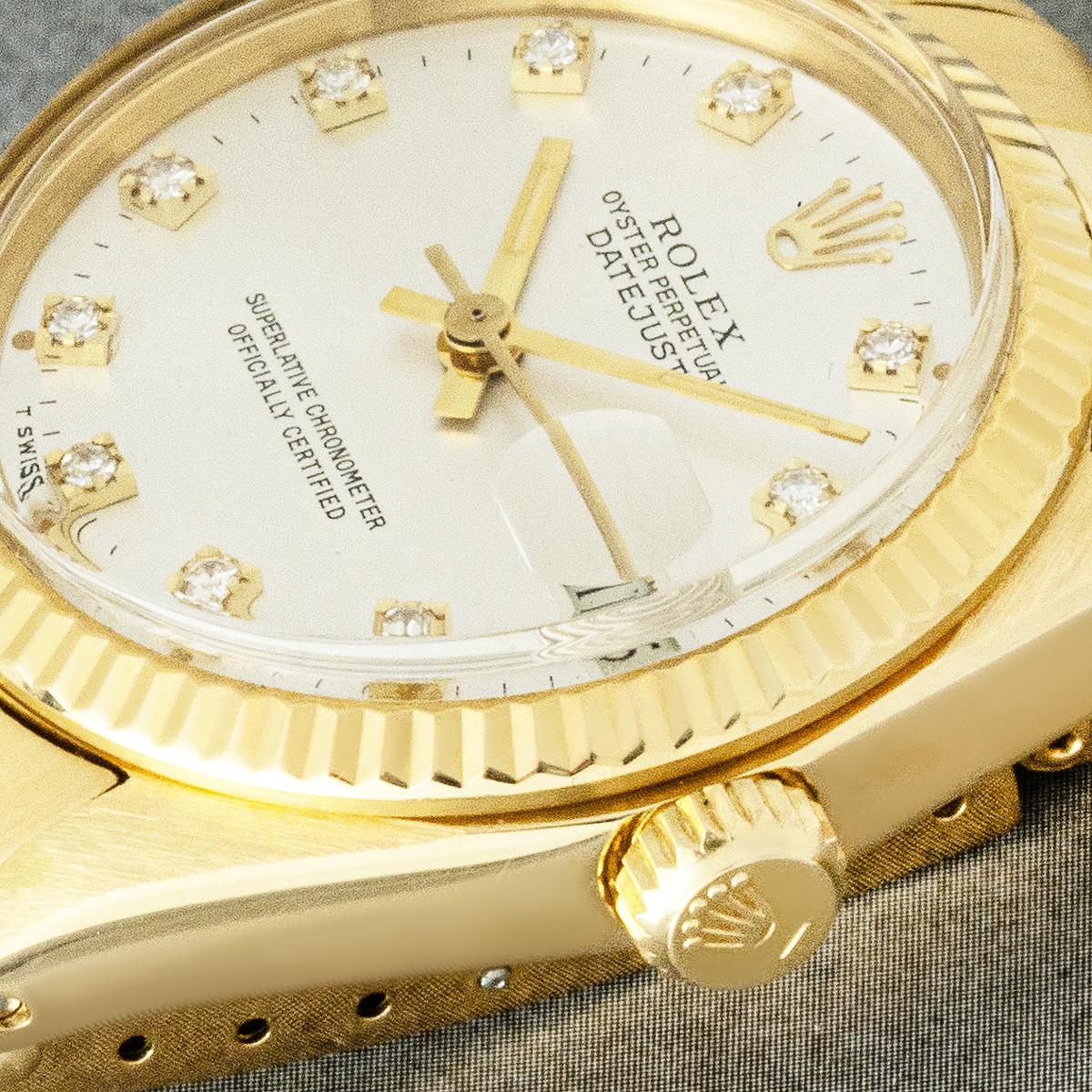 A midsize Rolex Datejust ref. 6827 crafted in 18k yellow gold. Featuring a silver dial with applied diamond hour markers and a fluted yellow gold bezel. The watch is also fitted with a plastic glass, self-winding automatic movement and a yellow gold