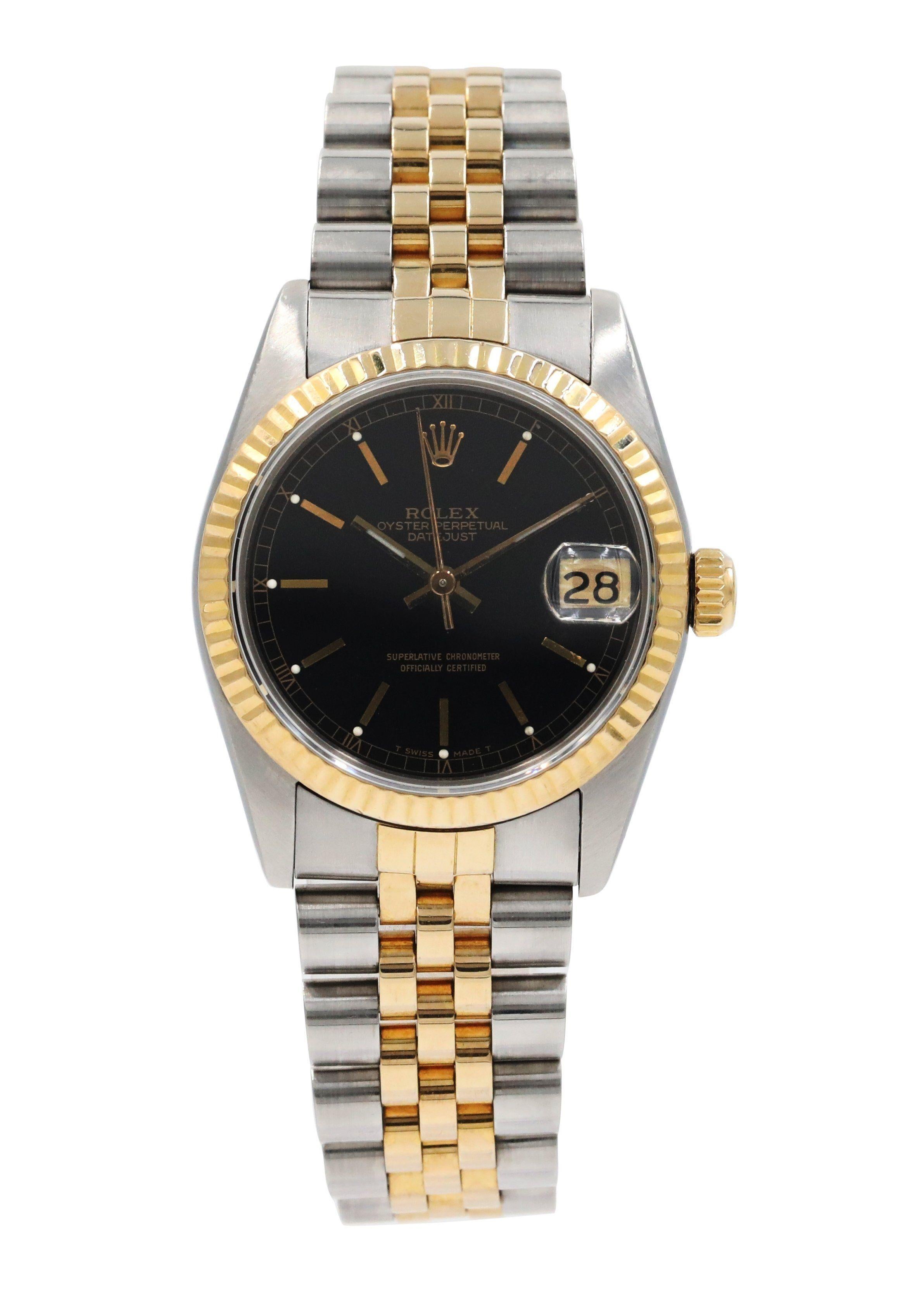 Rolex Datejust 68273 Ladies Watch.
31mm Stainless Steel case. 
Yellow Gold Stationary bezel. 
Black dial with Luminous Steel hands and index hour markers. 
Minute markers on the outer dial. 
Date display at the 3 o'clock position. 
Stainless Steel