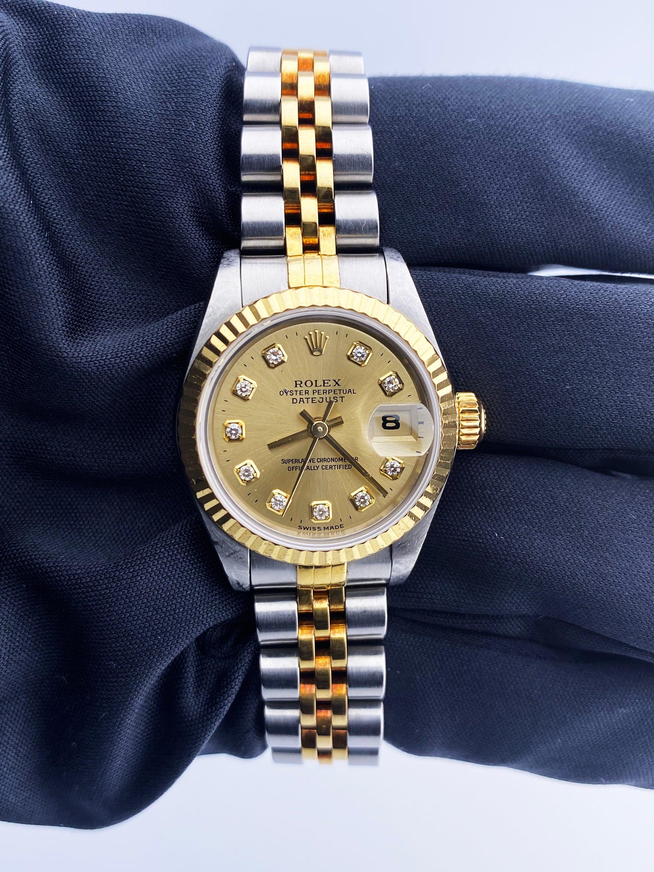 Rolex Oyster Perpetual Datejust 69173 Ladies Watch. 26mm stainless steel case. 18k yellow gold fluted bezel. Champagne dial with yellow gold hands and original factory diamond set hour markers. Magnified date display at 3 o'clock position. 18k