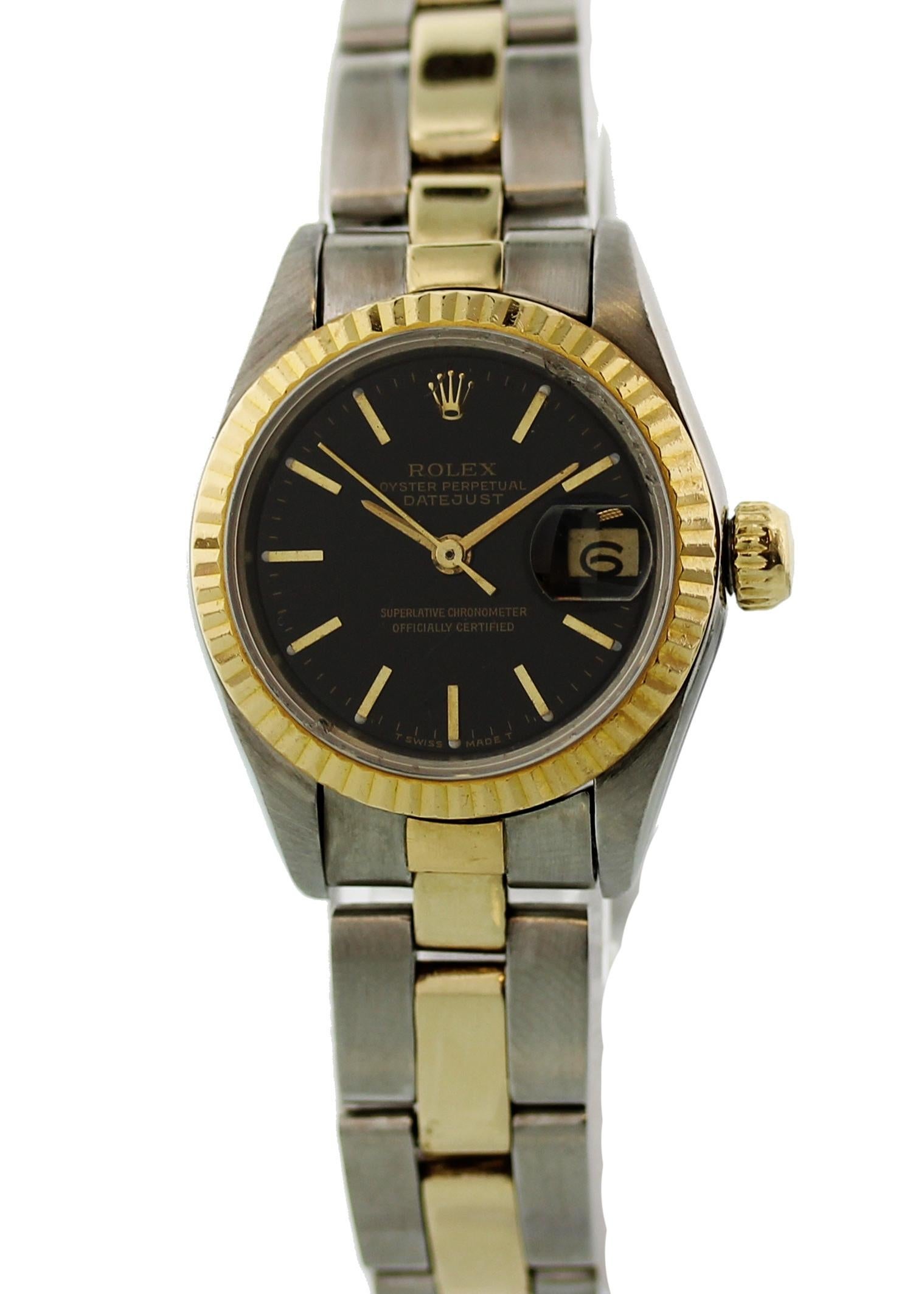 Rolex Datejust 69173 Ladies Watch. 26mm Stainless steel case. 18k yellow gold fluted bezel. Black dial with gold indexes and luminescent markers. Date display. Stainless steel and 18k yellow gold Oyster band. Will fit up to 6.5 Inch wrists.