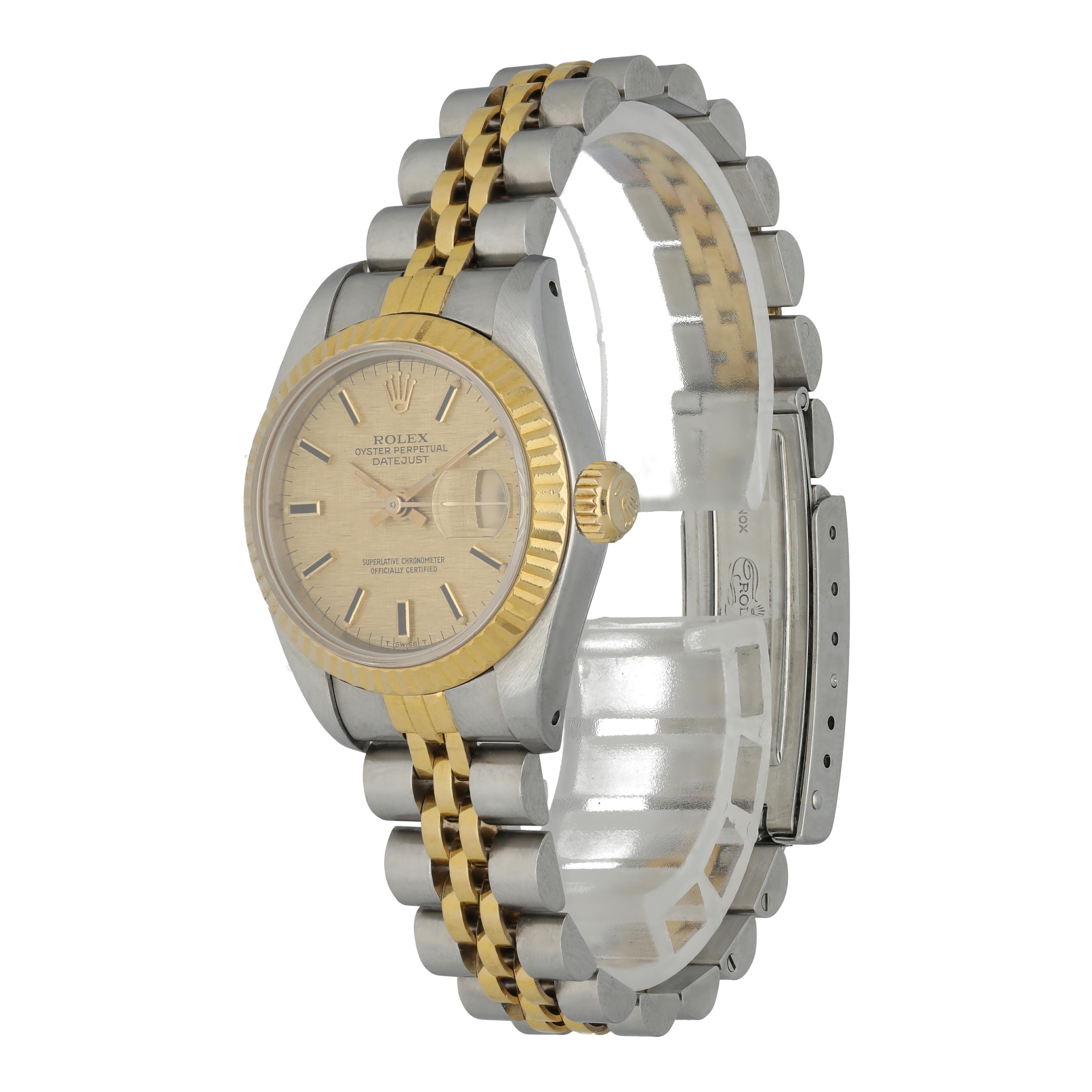 Rolex Datejust 69173 Ladies Watch. 
26mm Stainless Steel case. 
Yellow Gold Fluted Bezel. 
Champagne linen dial with gold hands and index hour markers. 
Minute markers on the outer dial. 
Date display at the 3 o'clock position. 
Stainless Steel &