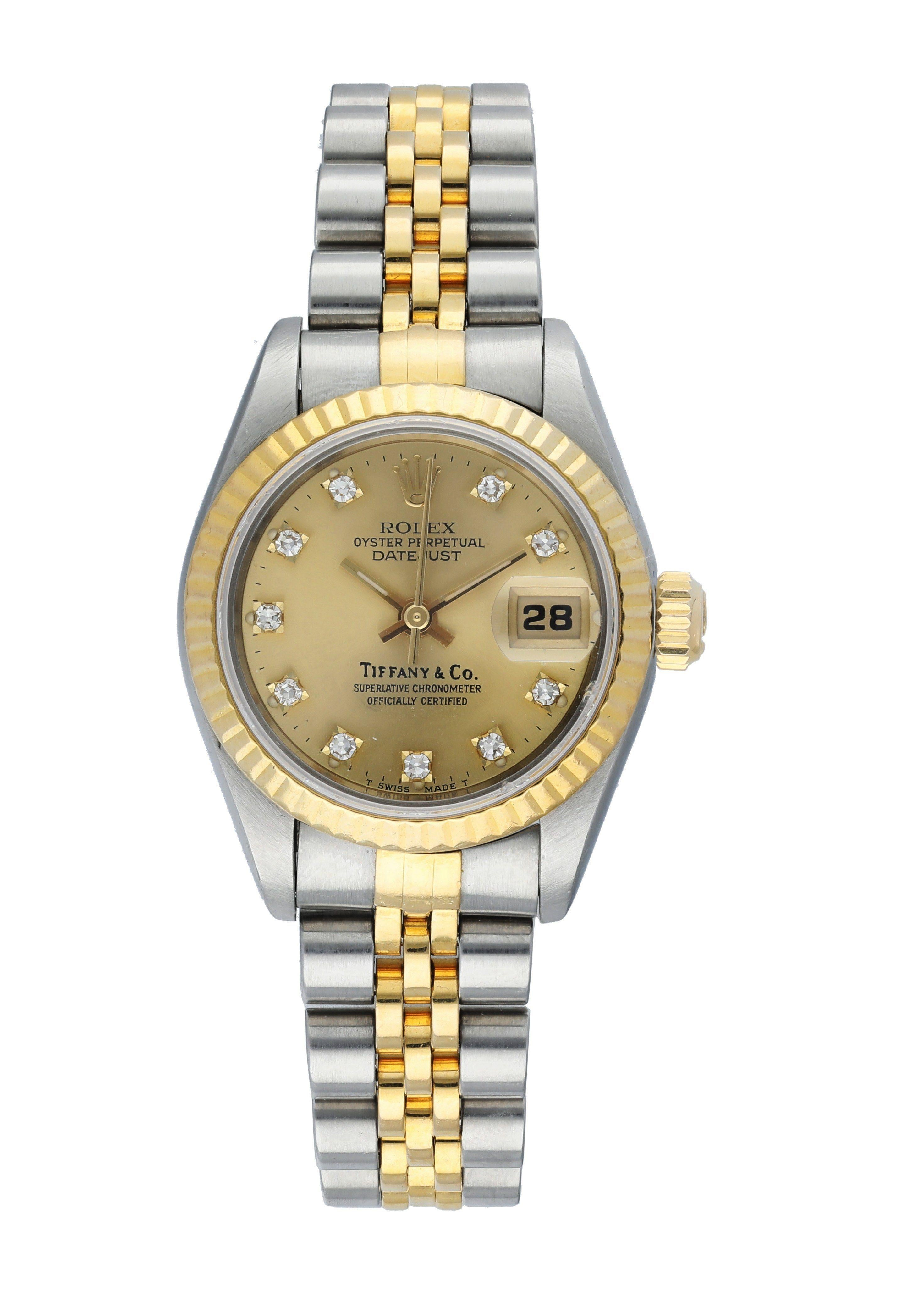 Rolex Datejust 69173 Ladies Watch. 
26mm Stainless Steel case. 
Yellow Gold Fluted Bezel. 
Champagne dial with gold hands and factory set diamond hour markers. Tiffany & Co. Stamp on Dial. 
Minute markers on the outer dial. 
Date display at the 3