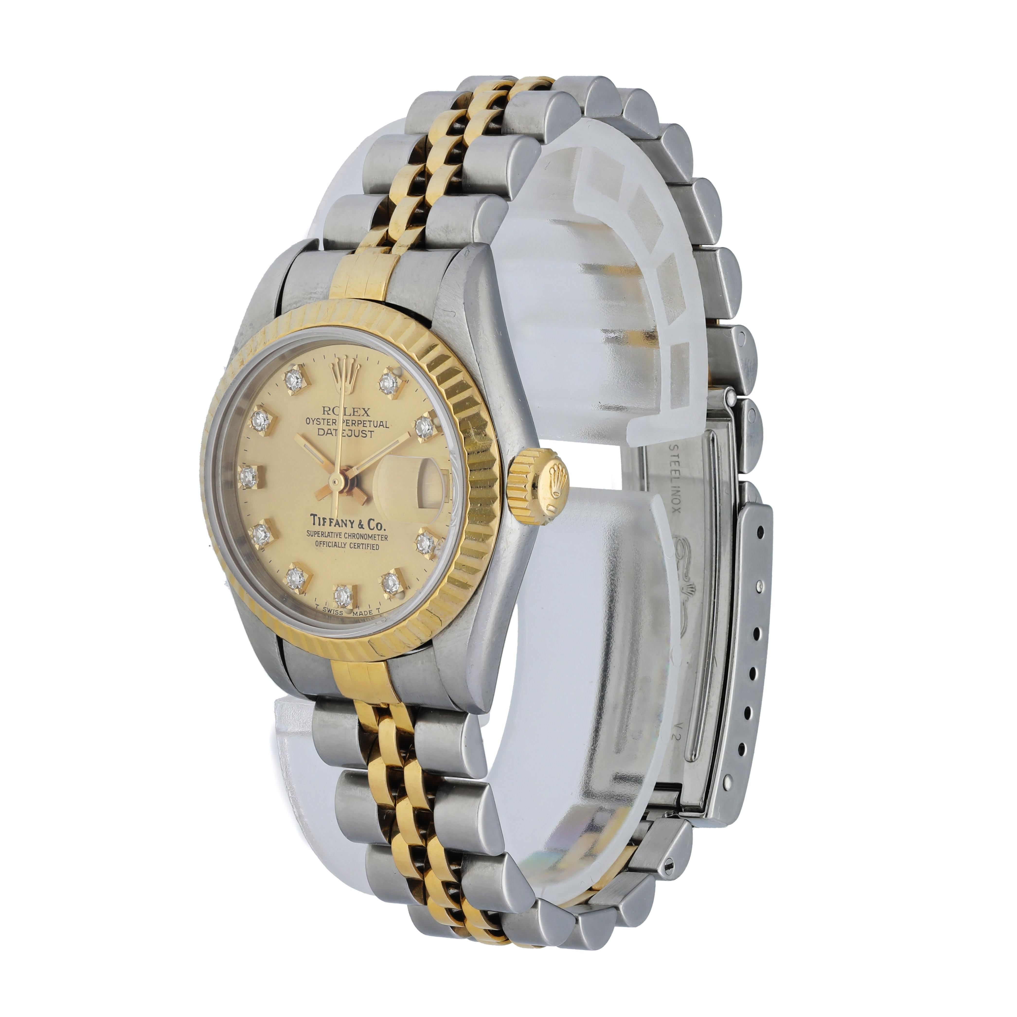 Rolex Datejust 69173 Ladies Watch. 
26mm Stainless Steel case. 
Yellow Gold Fluted Bezel. 
Champagne dial with gold hands and factory set diamond hour markers. Tiffany & Co. Stamp on Dial. 
Minute markers on the outer dial. 
Date display at the 3