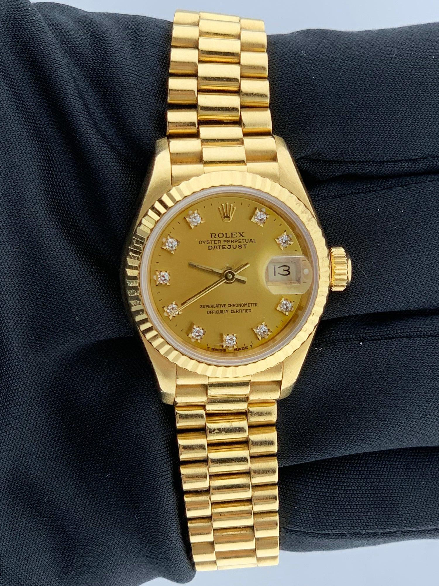 Rolex Oyster Perpetual Datejust 69178 ladies watch. 26mm 18K yellow gold case with a fluted bezel. Champagne dial with gold hands and original factory diamond set hour markers. 18K yellow gold president bracelet with 18K yellow gold hidden fold over