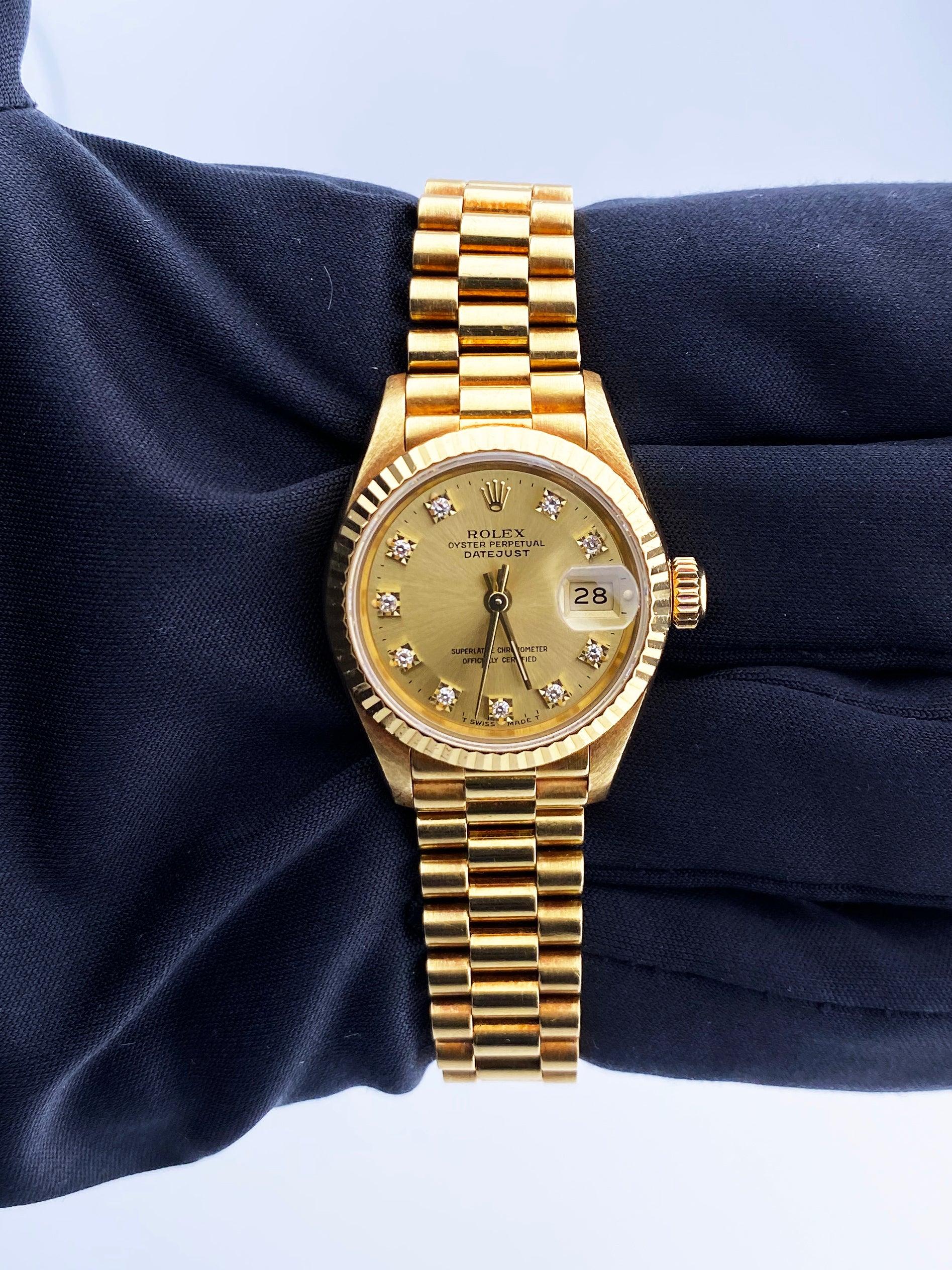 
Rolex Oyster Perpetual Datejust 69178 Ladies Watch. 26mm 18K yellow gold case with a fluted bezel. Champagne dial with gold hands and original factory diamond set hour markers. Minute markers on the outer dial. Date display at the 3 o'clock