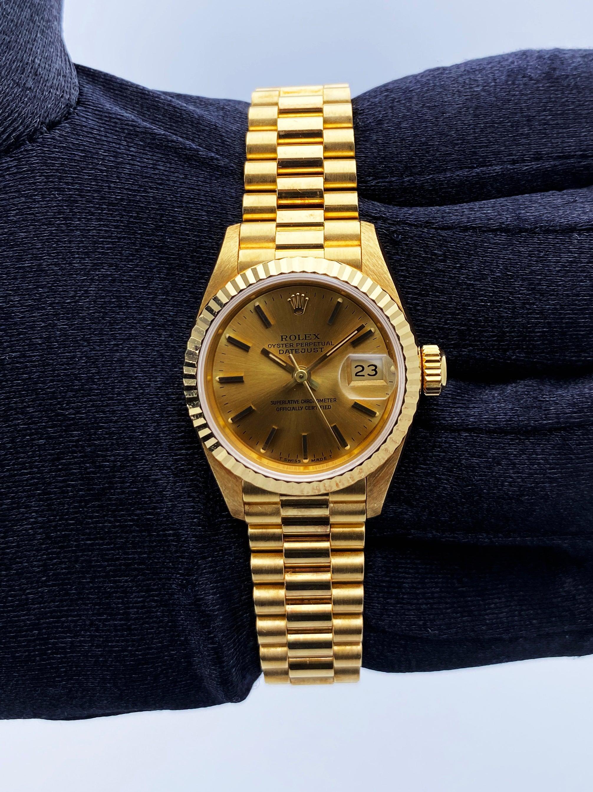 Rolex Oyster Perpetual Datejust 69178 Ladies Watch. 26mm 18K yellow gold case with a fluted bezel. Champagne dial with gold hands and index hour markers. Minute markers on the outer dial. Date display at the 3 o'clock position. 18K yellow gold