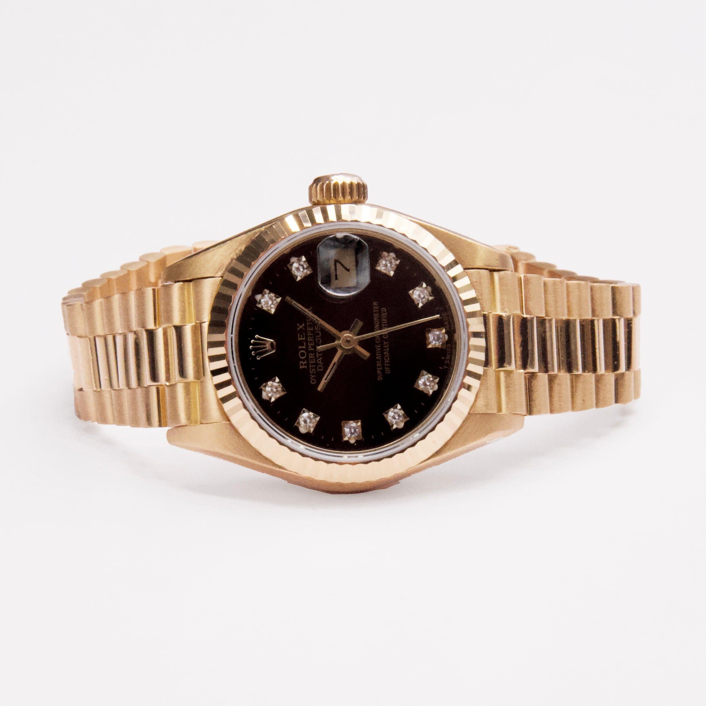 Rolex Oyster Perpetual Datejust 69178 Damenuhr. 26mm 18K Gelbgold Gehäuse mit einer geriffelten Lünette. Schwarzes Zifferblatt mit goldenen Zeigern und originalen, diamantbesetzten Stundenmarkierungen. Minutenmarkierungen auf dem äußeren