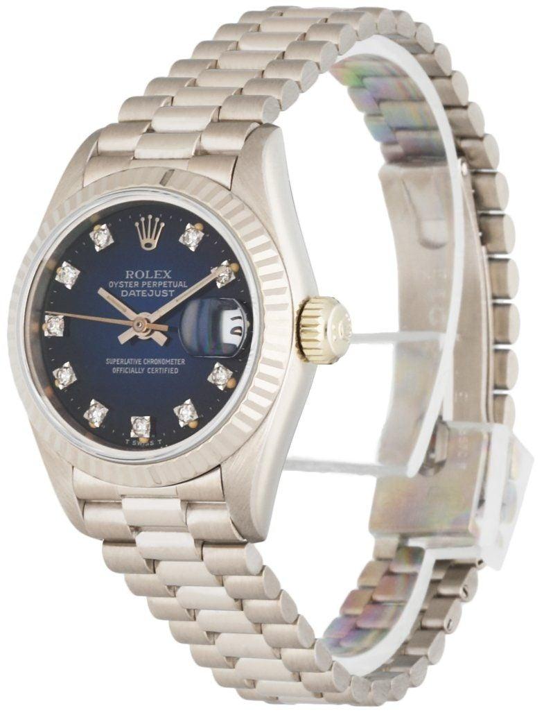 
Rolex Datejust 69179 ladies Watch. 26mm 18k White gold case. 18K White Gold fluted bezel. Blue dial with white gold hands and diamond hour markers. Minute markers on the outer dial. Date display at the 3 o'clock position. 18K white gold bracelet