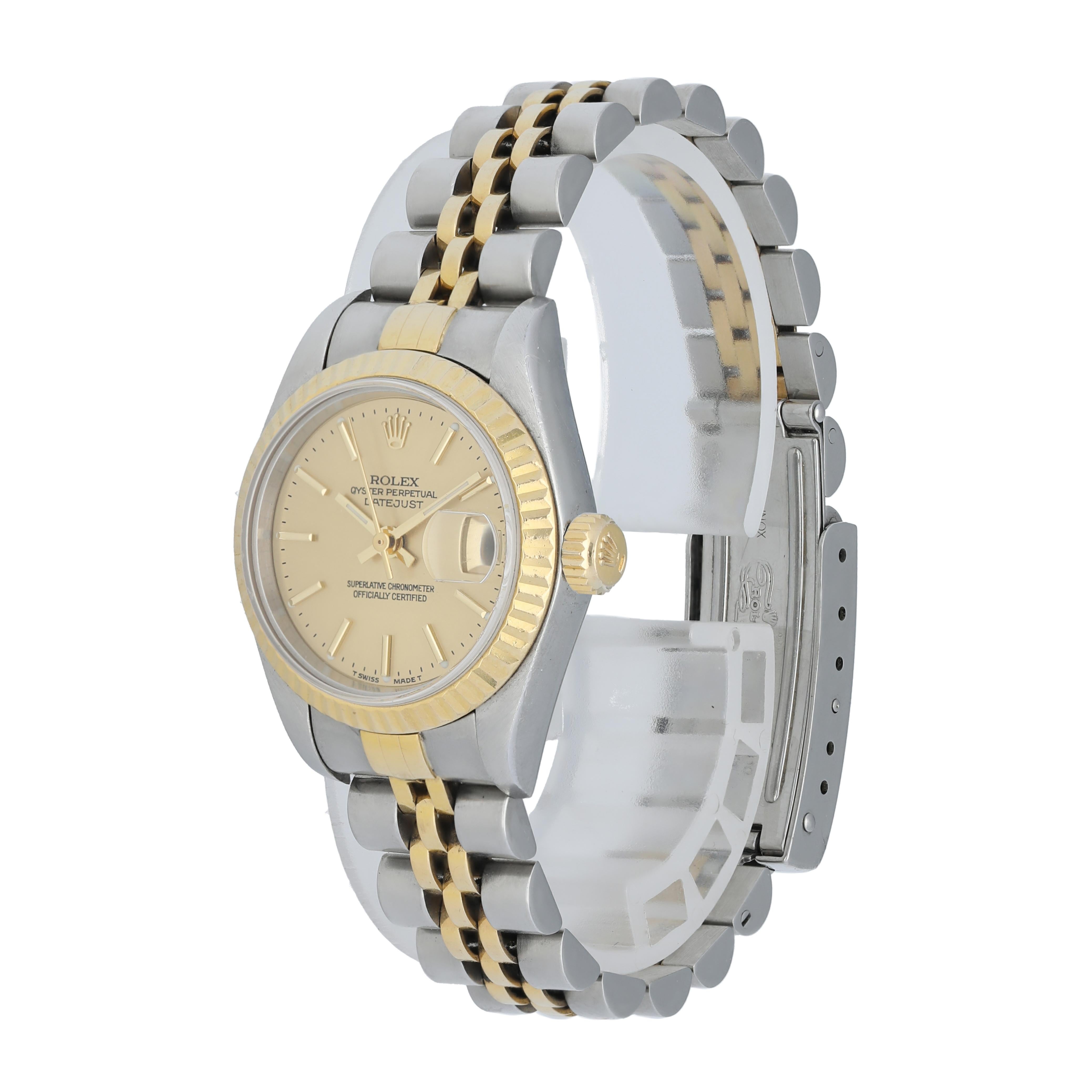 Rolex Datejust 79173 Ladies Watch.
26mm Stainless Steel case. 
Yellow Gold fluted bezel. 
Champagne dial with gold hands and index hour markers. 
Minute markers on the outer dial. 
Date display at the 3 o'clock position. 
Stainless Steel & 18K