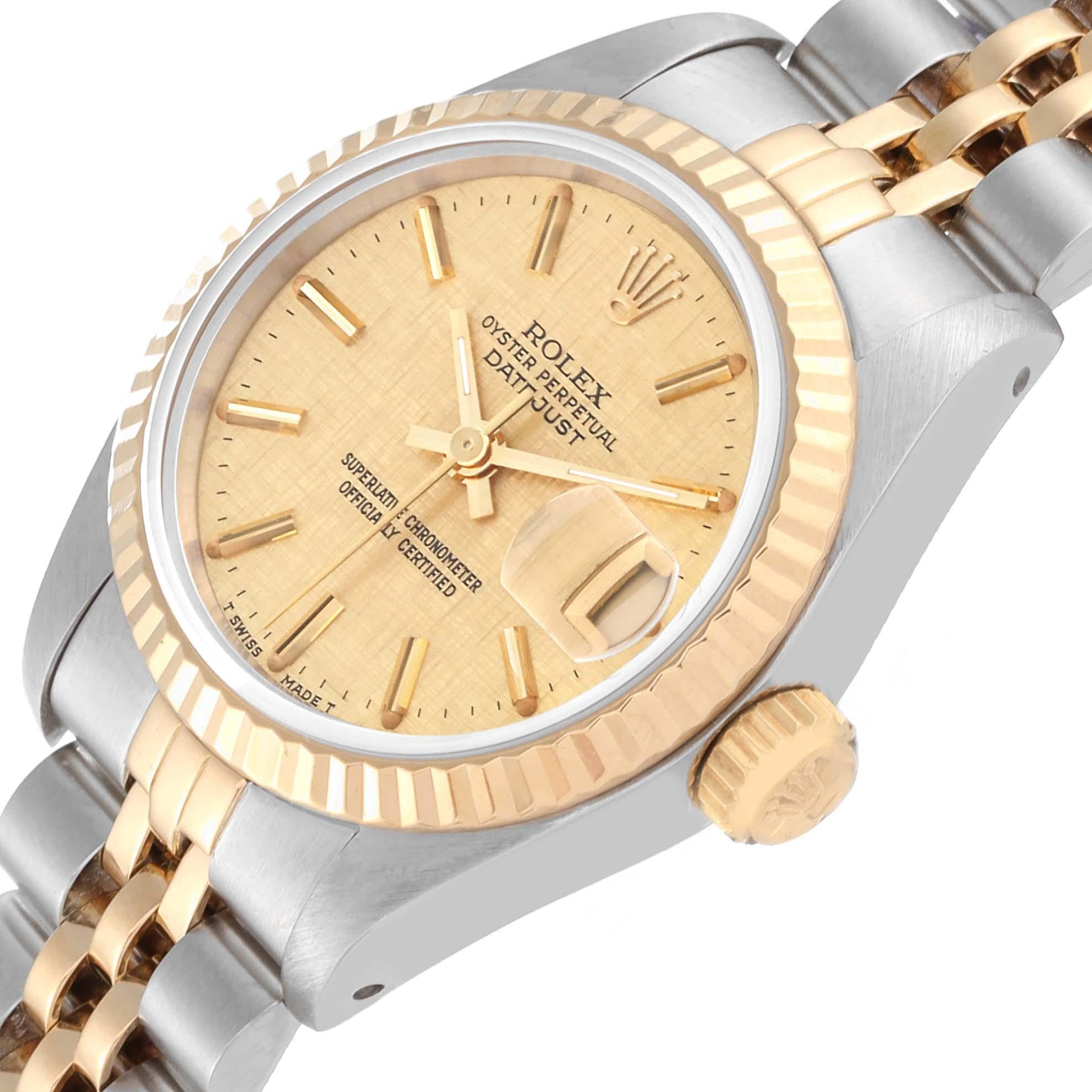 Rolex Datejust Champagne Linen Dial Steel Yellow Gold Ladies Watch 69173. Officially certified chronometer automatic self-winding movement. Stainless steel oyster case 26.0 mm in diameter. Rolex logo on the crown. 18k yellow gold fluted bezel.