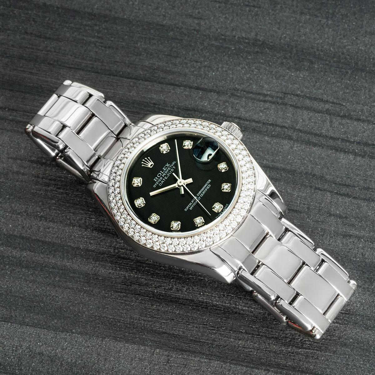 A white gold 34mm Datejust Pearlmaster by Rolex. Features a black diamond dial, complemented by a white gold bezel set with approximately 118 round brilliant cut diamonds. The timepiece is fitted with a sapphire crystal, self-winding automatic