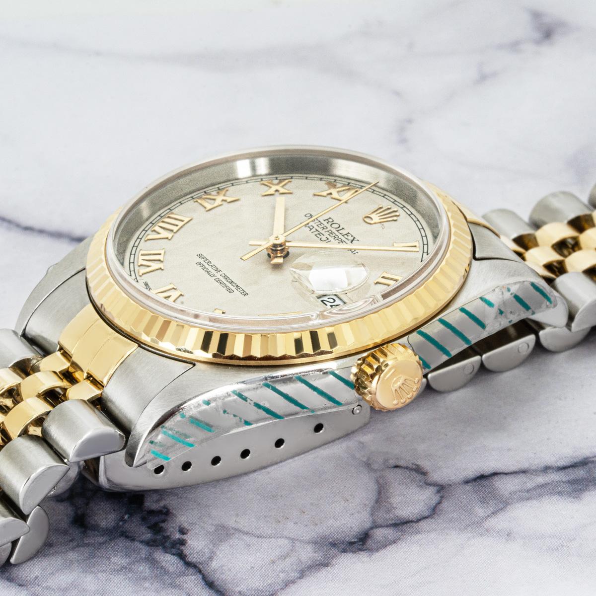 A classic 36mm Datejust by Rolex in stainless steel and yellow gold. Featuring an ivory pyramid dial with Roman numerals and a fluted yellow gold bezel. The Jubilee bracelet features a folding Oysterclasp. Fitted with scratch-resistant sapphire