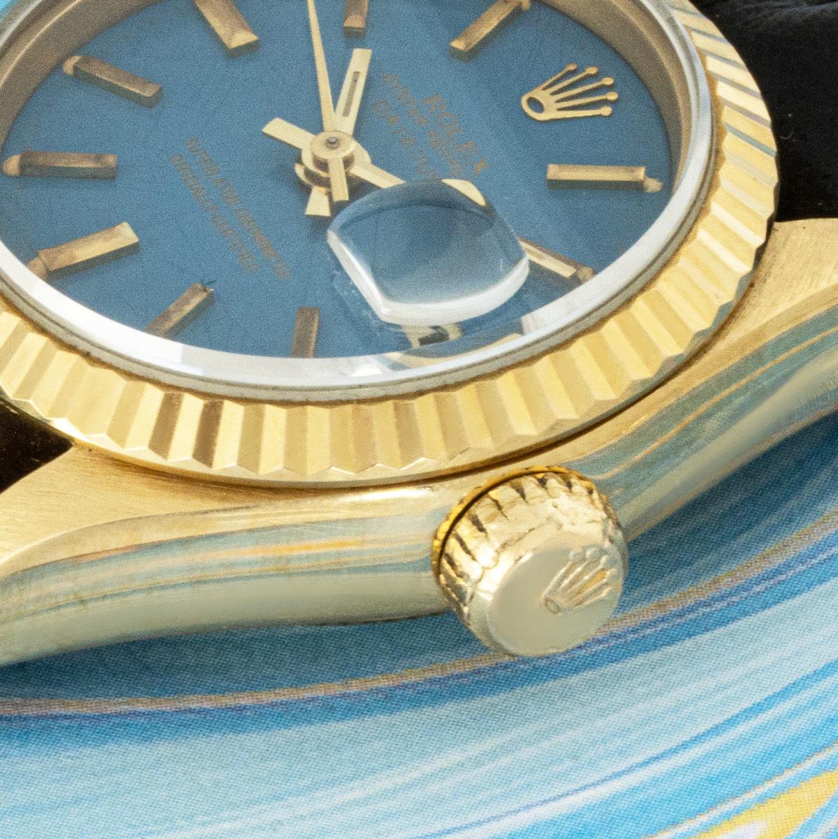 Une Datejust en or jaune de 26 mm de Rolex. Elle est dotée d'un rare cadran bleu Stella, complété par une lunette cannelée en or jaune. A noter que le cadran s'est quelque peu 