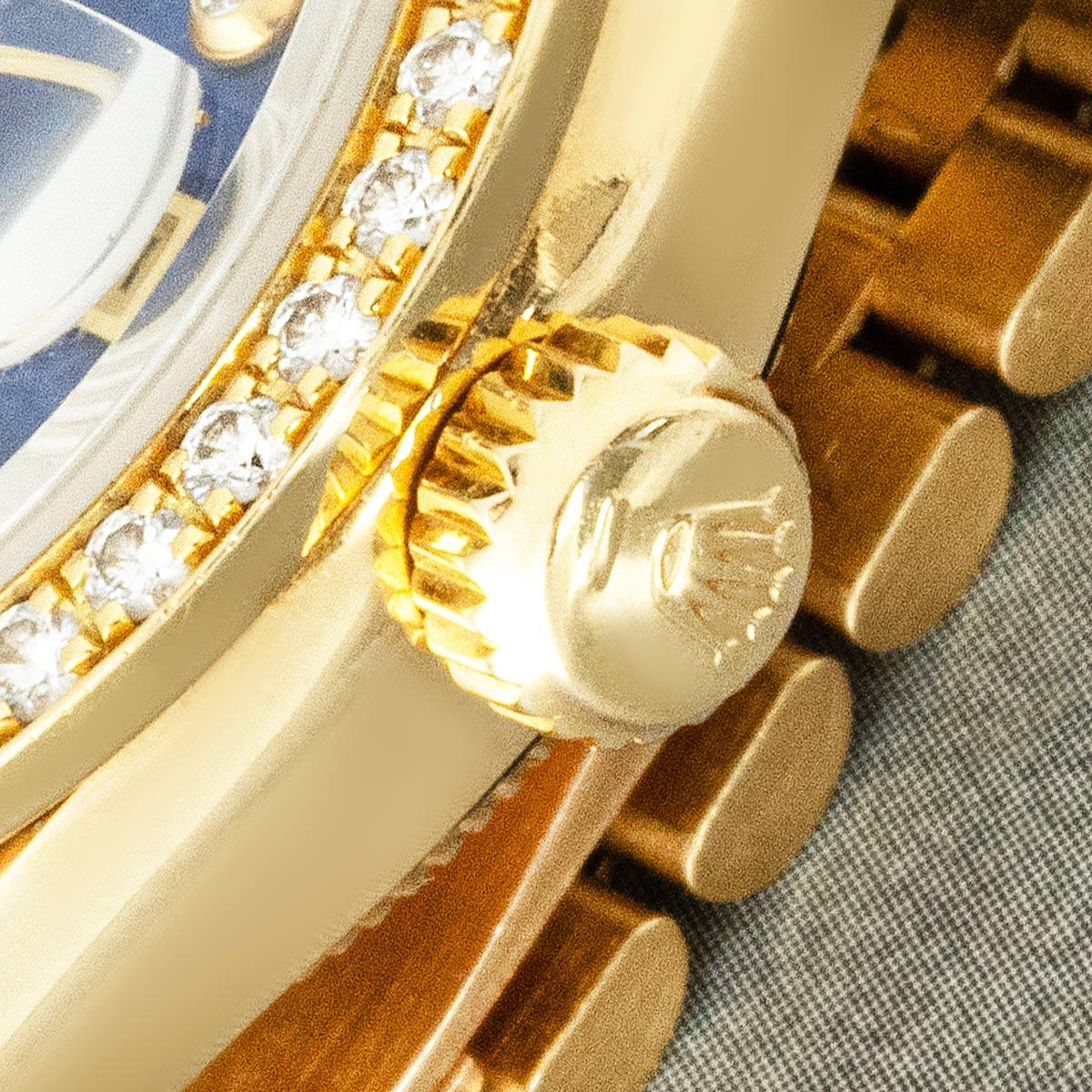 A 26mm yellow gold Datejust by Rolex. Features an exceptionally rare lapis pyramid dial with diamond set hour markers, complemented by the bezel, set with 40 round brilliant cut diamonds.

Fitted with a sapphire crystal and self-winding automatic