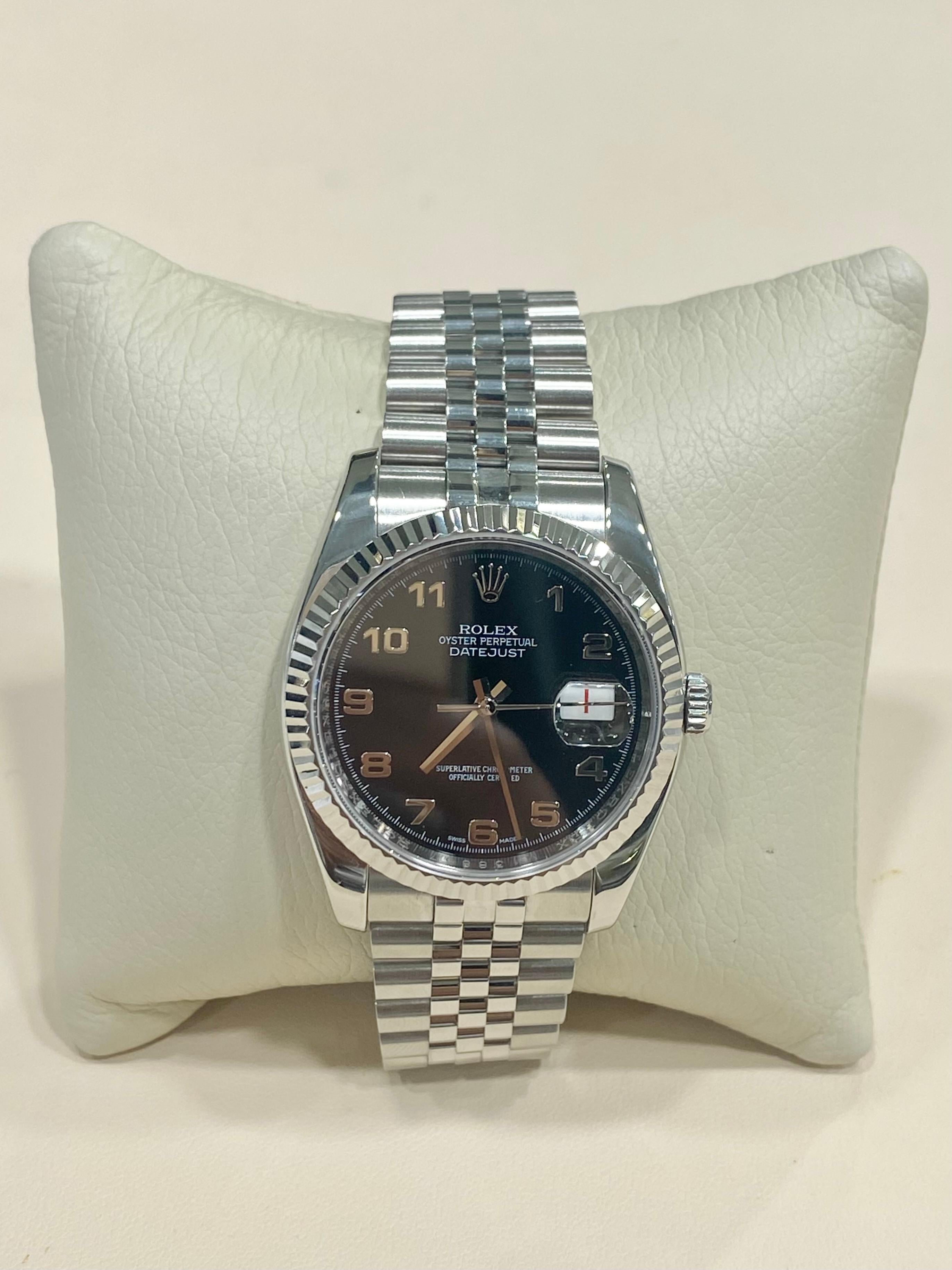 Rolex Datejust, 36 mm, ganz aus Stahl. Diese schöne Uhr verfügt über ein schwarzes Zifferblatt mit arabischen Ziffern und eine auffällige, geriffelte Lünette aus Edelstahl. Dieses Modell hat ein Saphirglas mit einer Datumslupe und einem Datumsrad im