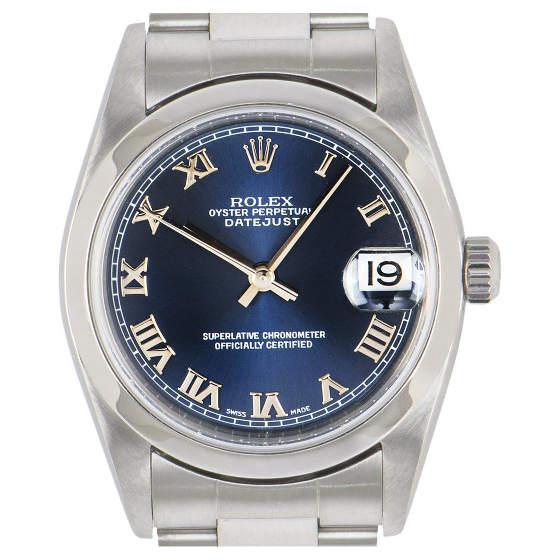 A ladies Datejust wristwatch in stainless steel by Rolex, features a blue dial with roman numerals and a smooth bezel. The watch is equipped with an oyster bracelet and deployant clasp. It is also fitted with sapphire crystal and automatic