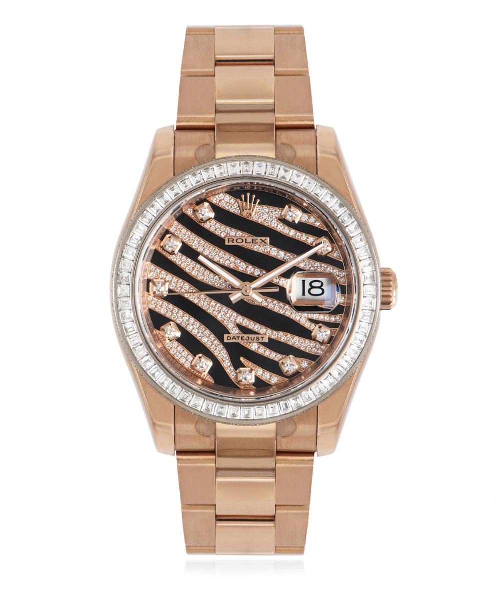 A 36mm mens NOS Datejust wristwatch in 18k rose gold by Rolex. Featuring a black zebra pave diamond dial with diamond set hour markers. Complimenting the dial is a fixed rose gold bezel set with 60 baguette cut diamonds weighing 2.00ct and is