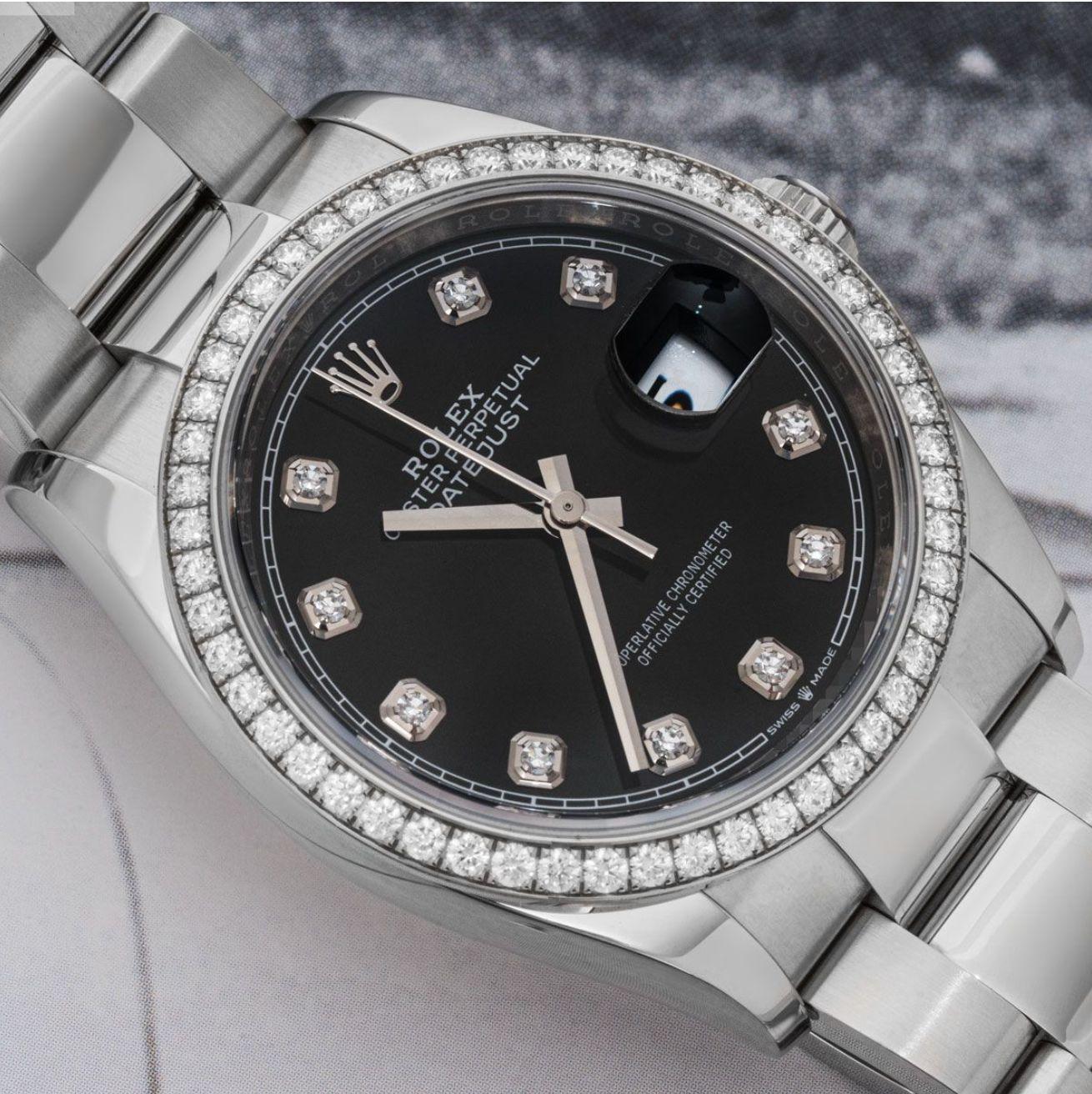 A 36mm Datejust in Oystersteel by Rolex. Featuring a black dial with diamond set hour marker and a fixed bezel set with 52 round brilliant cut diamonds. Fitted with a scratch-resistant sapphire crystal and a self-winding automatic movement. The
