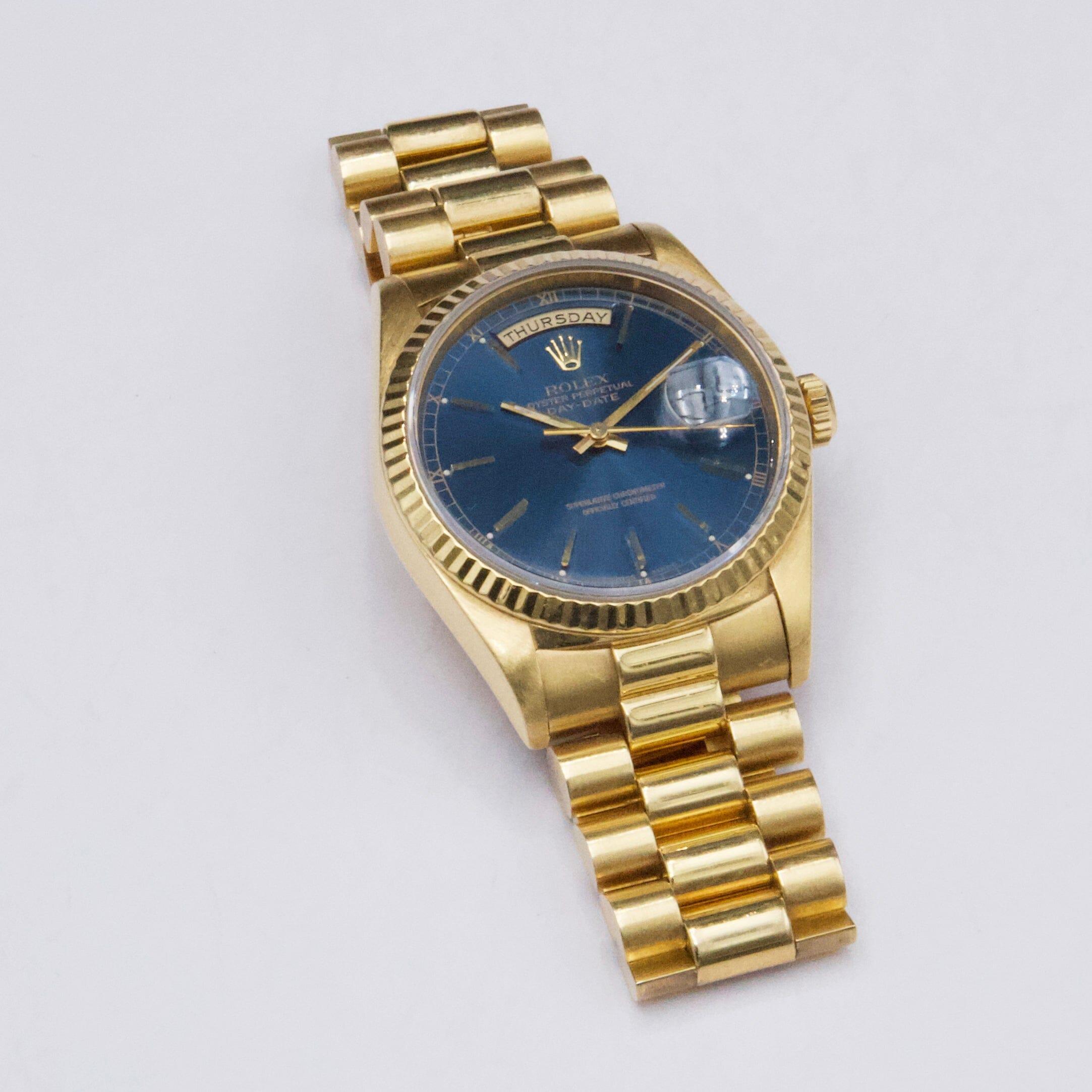 Rolex Day Date 18238 Mens Watch. 36mm 18K yellow gold case. 18K yellow gold fluted bezel. Blue dial with gold hands and index hour marker. Date display at 3 o'clock position and day display at 12 o'clock position. 18K yellow gold President bracelet