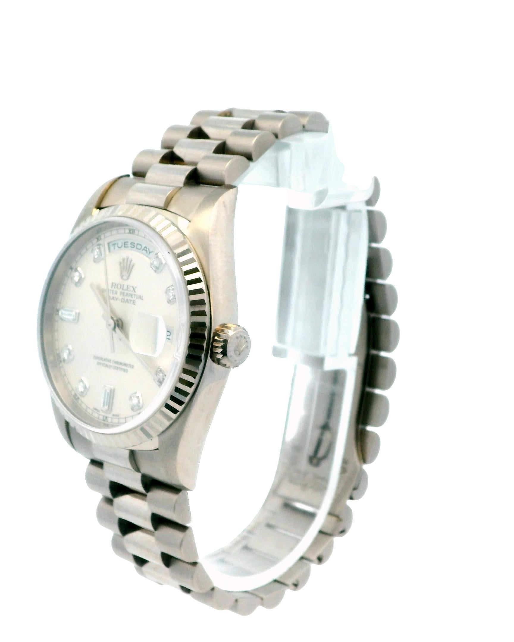 Rolex Day-Date 18239 Herrenuhr. Dieser Zeitmesser besitzt ein 36-mm-Gehäuse aus 18 Karat Weißgold, das durch eine kannelierte Lünette aus 18 Karat Weißgold ergänzt wird. Das silberne Zifferblatt ist mit silberfarbenen Zeigern akzentuiert und hat