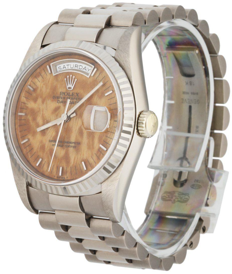 
Rolex Day Date 18039 Men's Watch. 36mm 18k White Gold case.18K White Gold fluted bezel. Wood dial with gold luminous hands and index hour markers. Minute markers on the outer dial. Date display at the 3 o'clock position and Day display at 12