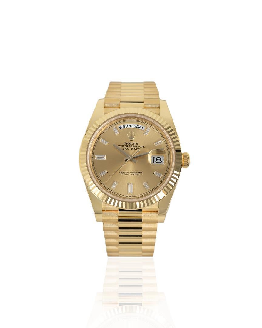 The self-winding Rolex Day-Date 40 is showcased here in 18ct yellow gold, with a 40 mm diameter, mono-bloc middle case screw-down case back, and winding crown with Twinlock double waterproofness system. Complementing the case is the Champagne