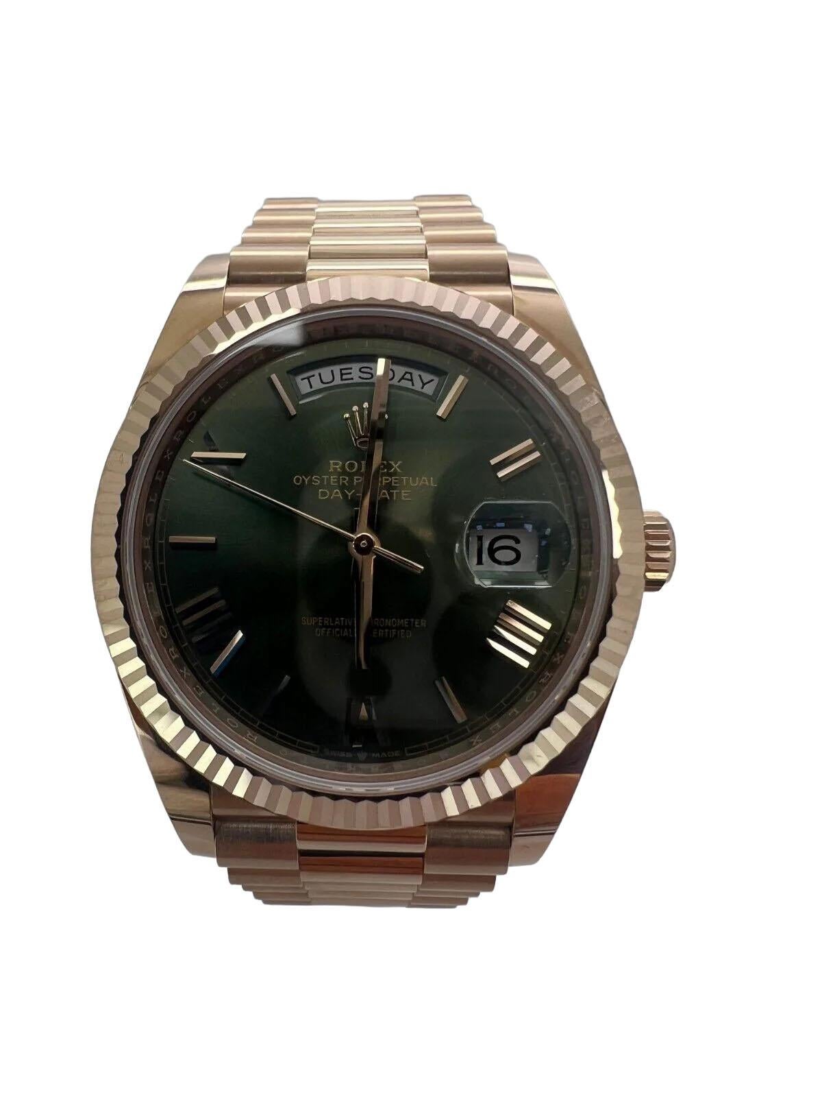 Te presentamos el Rolex Day-Date 228235, un opulento reloj de pulsera con esfera de color oliva y un característico bisel rosa. Este reloj tiene un fondo de caja macizo, un tipo de bisel estriado y números romanos e índices bastón como índices.