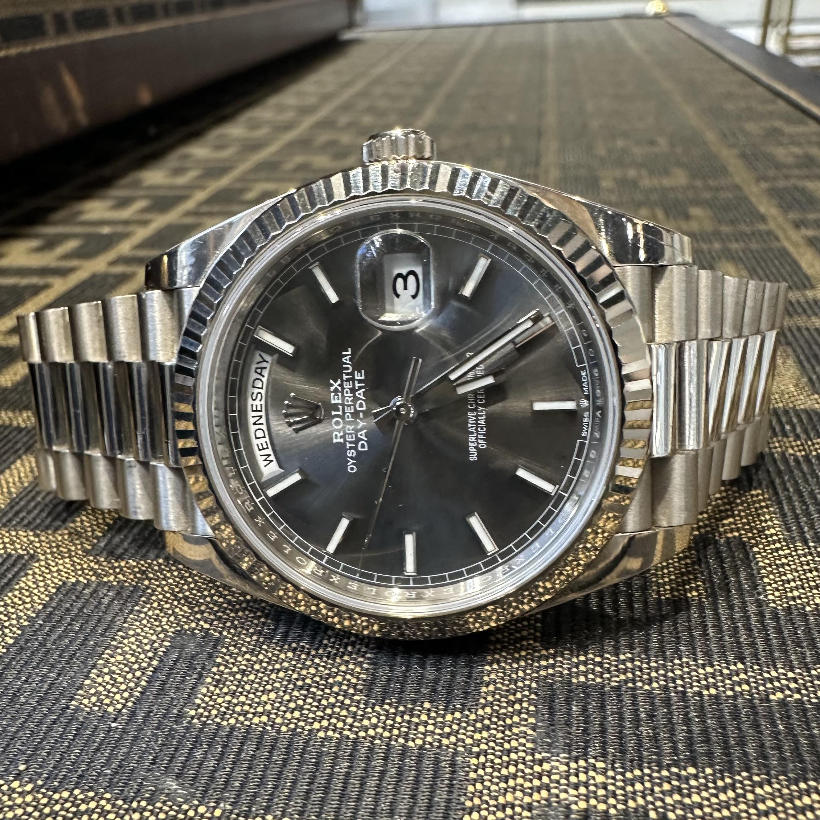 Brand: Rolex 
Model: Day-Date 40 “President”
Day-Date 40 
Model Number: 228239
Movement: Automatic
Case Material: 18k White Gold
Case Size: 40 mm
Bezel: White Gold Fluted
Dial: Slate Gray, Luminous Index Stick Hour Markers
Bracelet: President, 18k