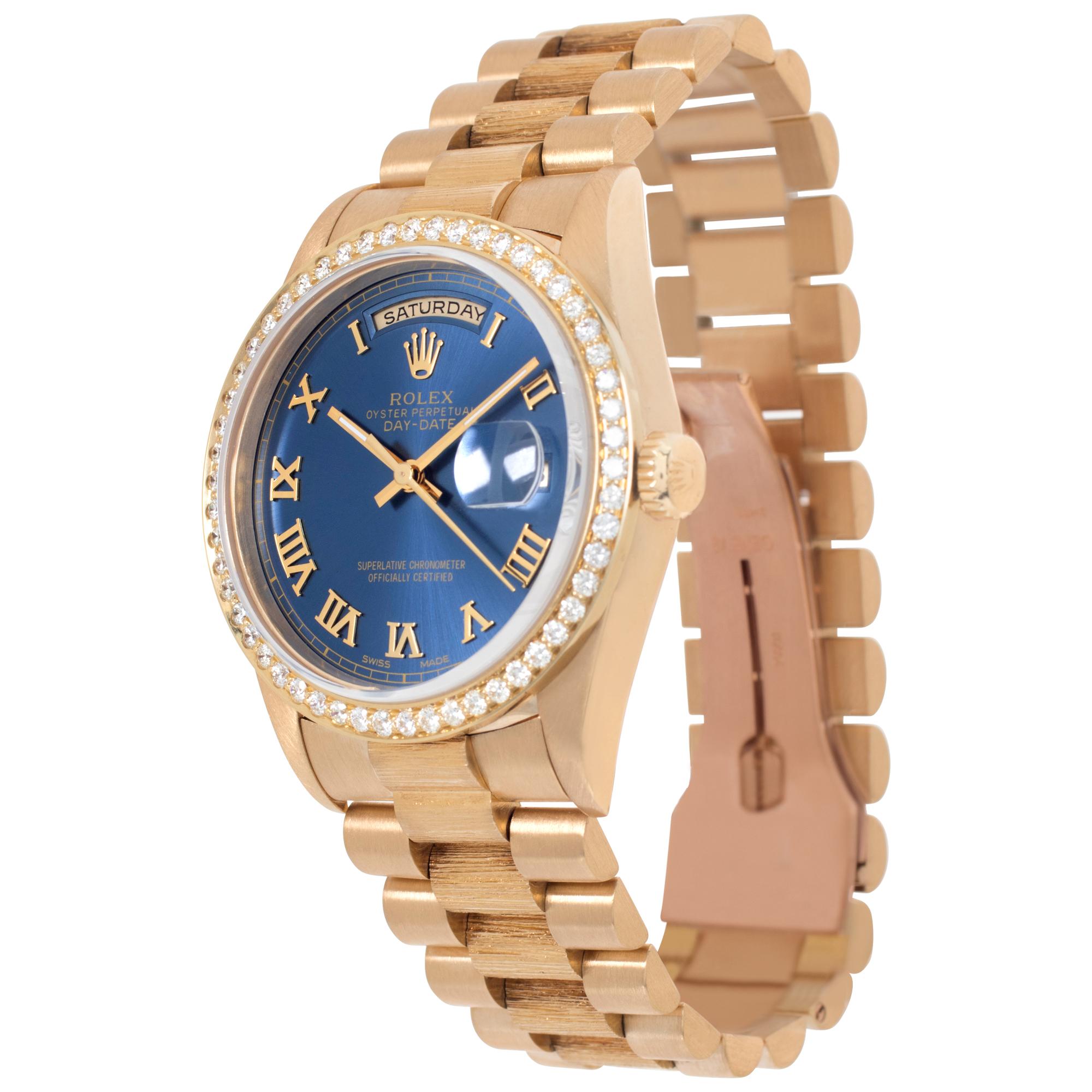 Rolex Day-Date in 18k yellow gold with factory original bark finish President band with custom blue dial with applied Roman numerals and custom diamond bezel. Auto w/ sweep seconds, date and day. 36 mm case size. **Bank wire only at this price** Ref