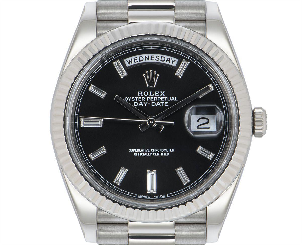 Diese Day-Date 40 228239 ist ein außergewöhnliches Exemplar des Flaggschiffs von Rolex. Sie ist aus massivem 18-karätigem Weißgold gefertigt und verfügt über ein auffallend helles schwarzes Zifferblatt mit Sonnenschliff, das von 10 Diamantindexen im