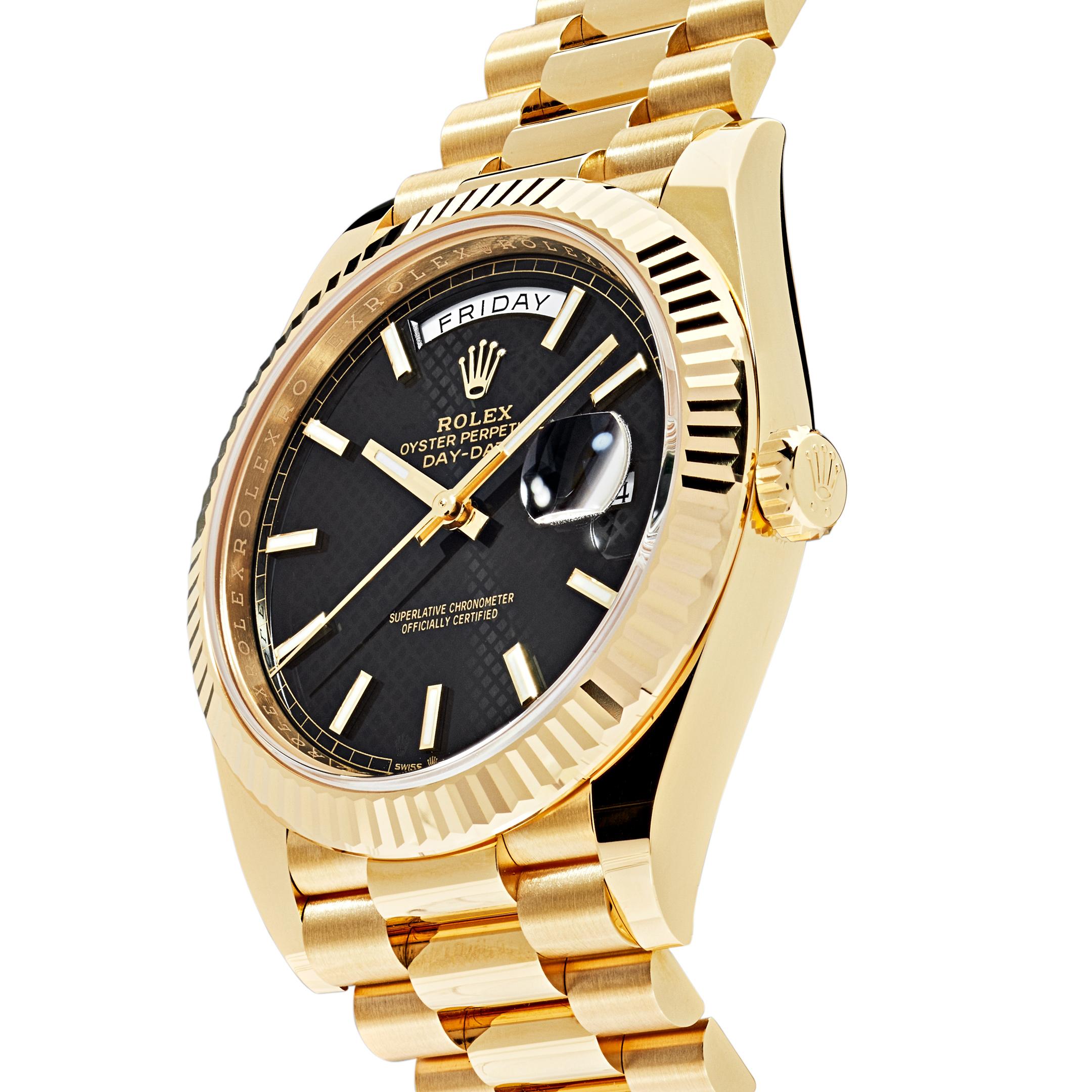 The Oyster Perpetual Day-Date is inlaid in a sophisticated 40mm 18k yellow gold case surrounding a black, diagonal-motif dial with chromalight index markers and hands. The signature fluted bezel is a distinctive feature for the Rolex brand. The
